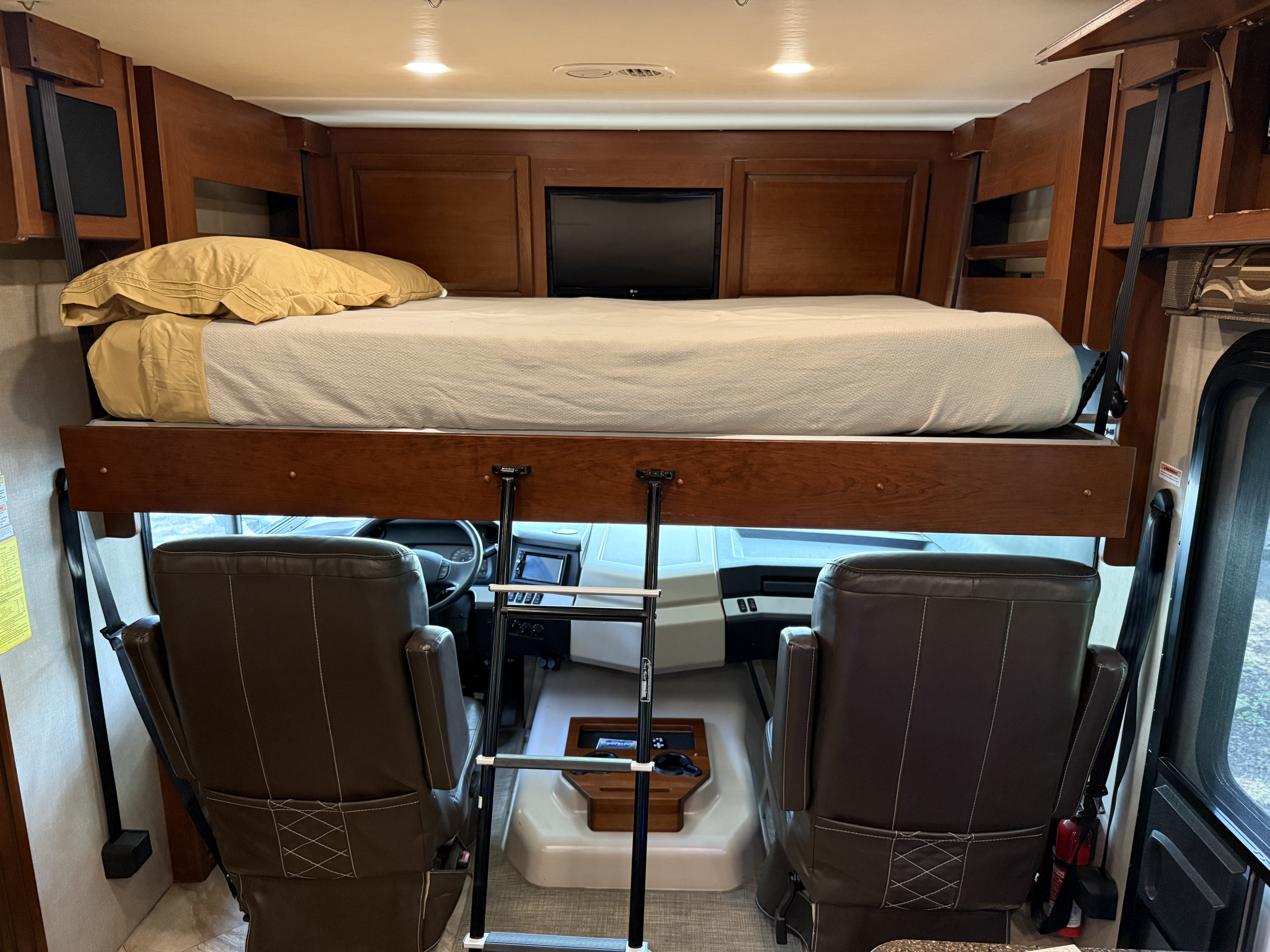 This RV rental features an overhead bunk bed with a ladder, providing extra sleeping space above the motorhome's driver's cabin.. Fleetwood Bounder 2016