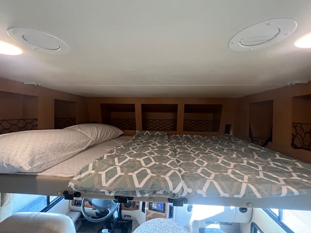 RV rental: Overhead bunk bed with bedding & storage cubbies, providing a cozy sleeping area above the cockpit.. Thor ACE 2015