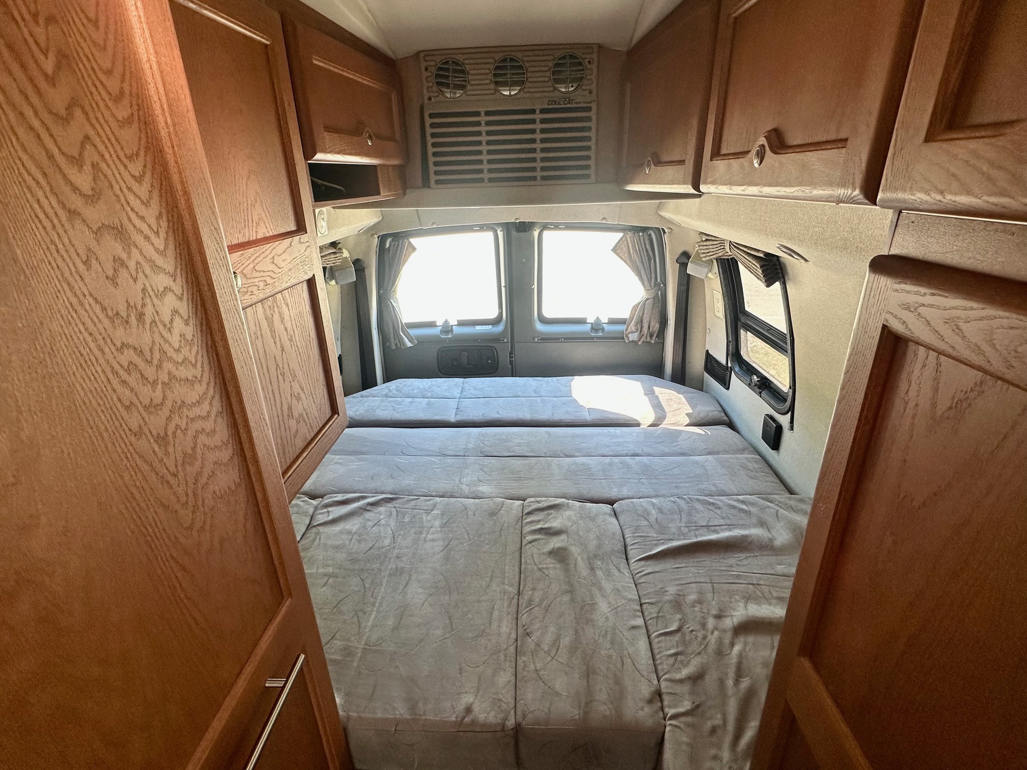 Step inside this inviting RV rental with a comfy modular bed, overhead cabinets, and bright rear windows. Your road trip awaits!. Roadtrek Ranger Rt 2012