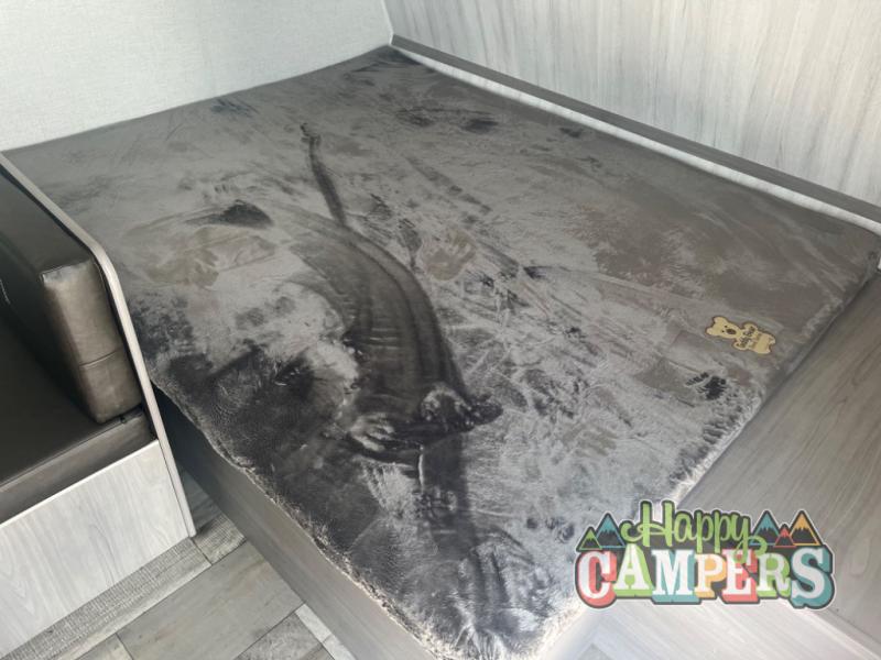 RV rental bunk bed interior: soft grey blanket with a teddy bear tag, ready for a cozy night's sleep.. Dutchmen Coleman Lantern LT 2023