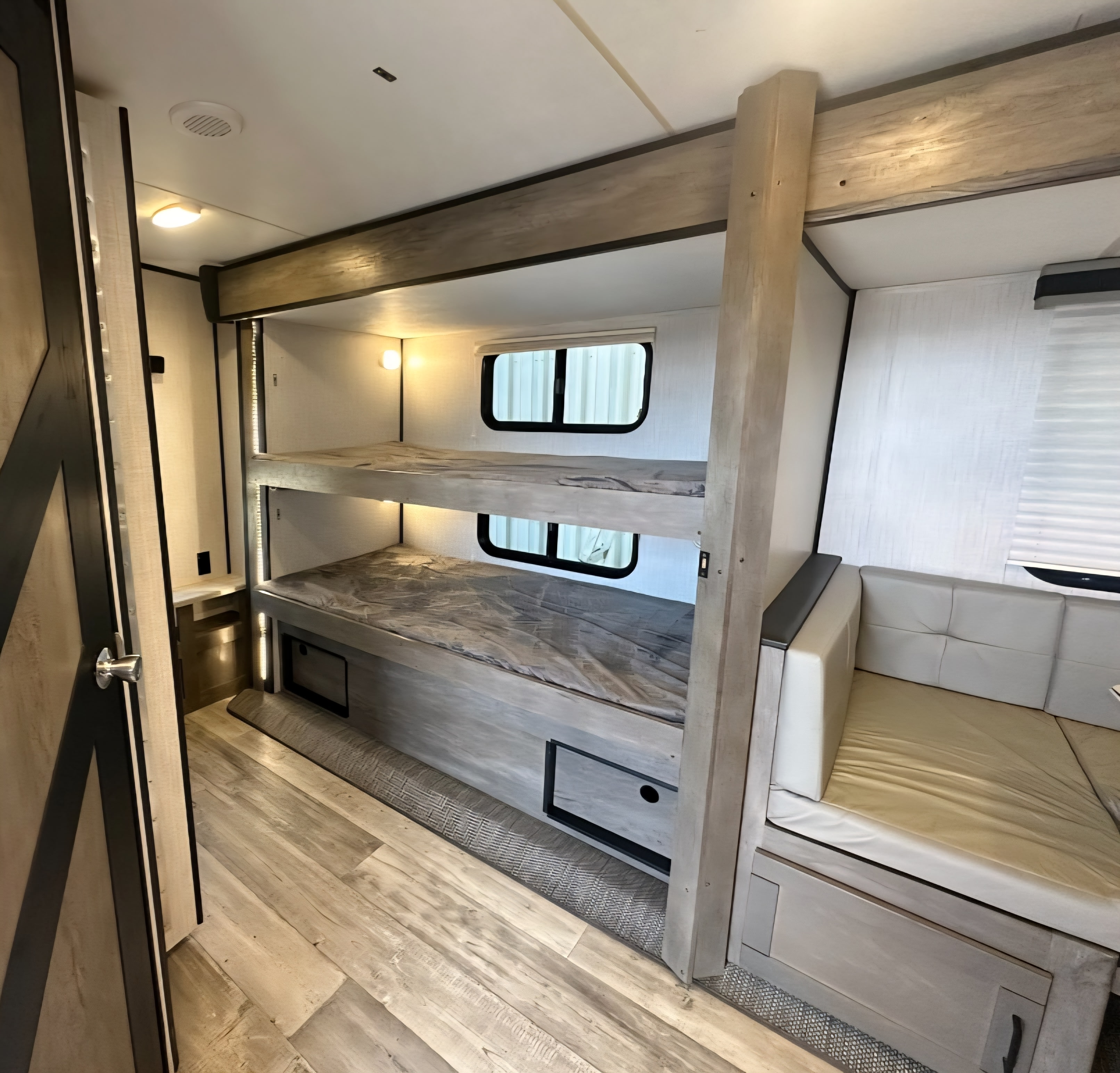 Inside this modern **RV rental**: two comfortable bunk beds, a spacious couch, and bright wood-look flooring.. Heartland RVs North Trail 2021