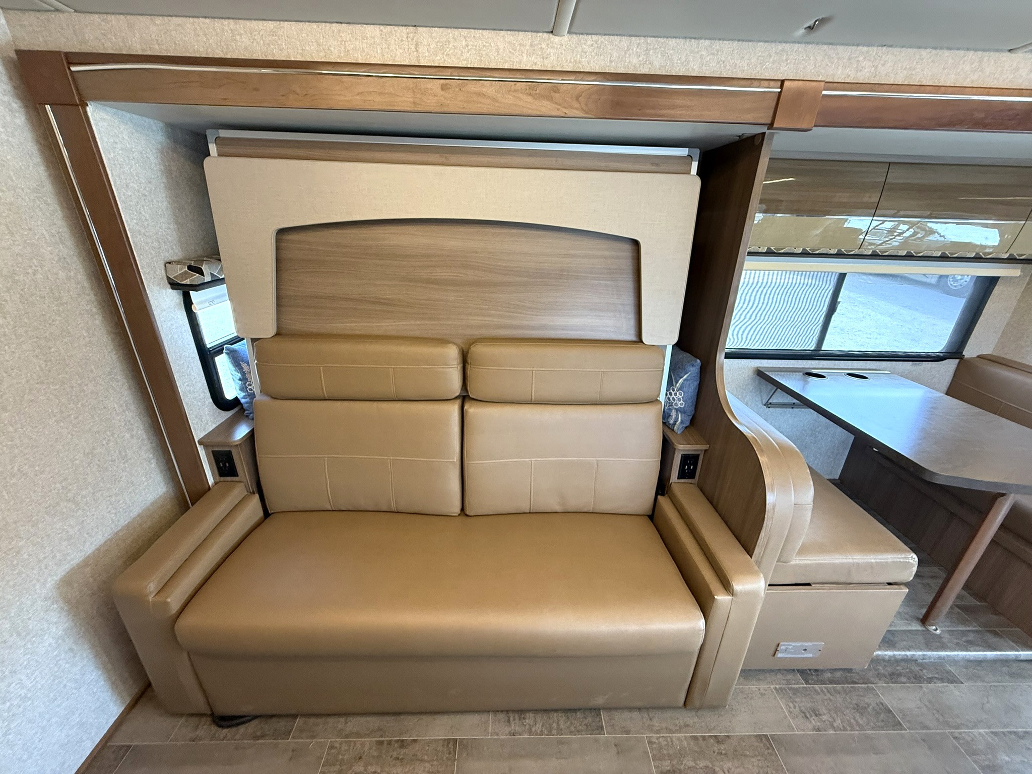 RV rental interior featuring a versatile convertible sofa bed, an upper pull-down bunk, and a dinette for dining/seating.. Winnebago View 2019