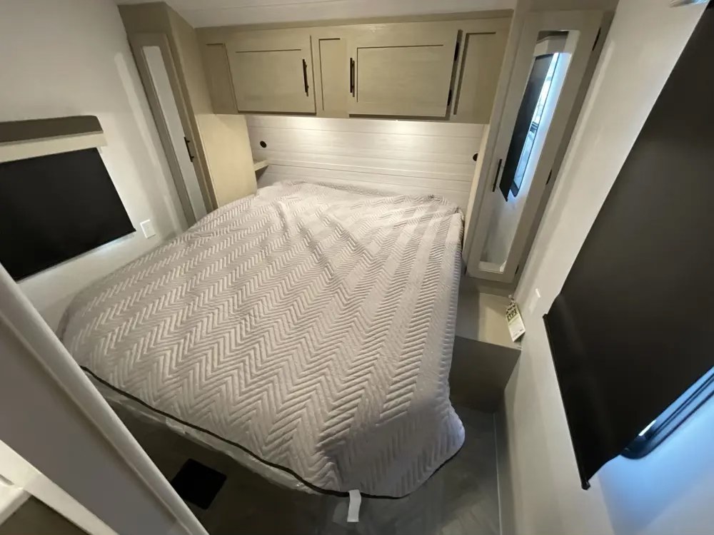 Discover comfort in this modern rv rental bedroom. Features a cozy bed, overhead storage, and side windows for restful travel.. Forest River Salem Platinum 2024