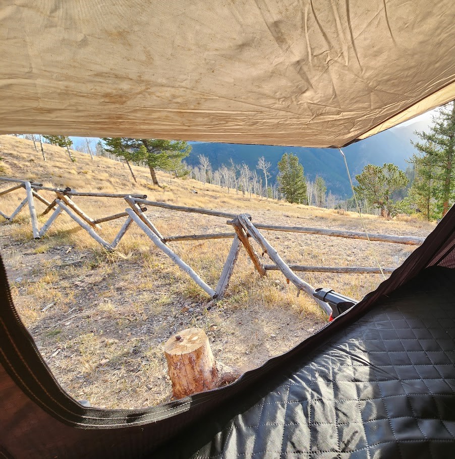 Morning view from an RV rental, showing a cozy sleeping area, rustic fence, and a scenic mountain landscape.. Chevrolet Silverado 1500 Trail Boss 2020