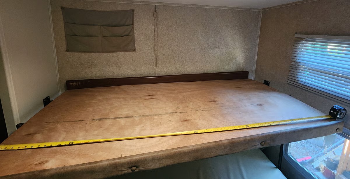 Measuring an RV rental bunk bed platform for custom bedding or a mattress, shown with a tape measure.. Keystone RV Outback Sydney 2007