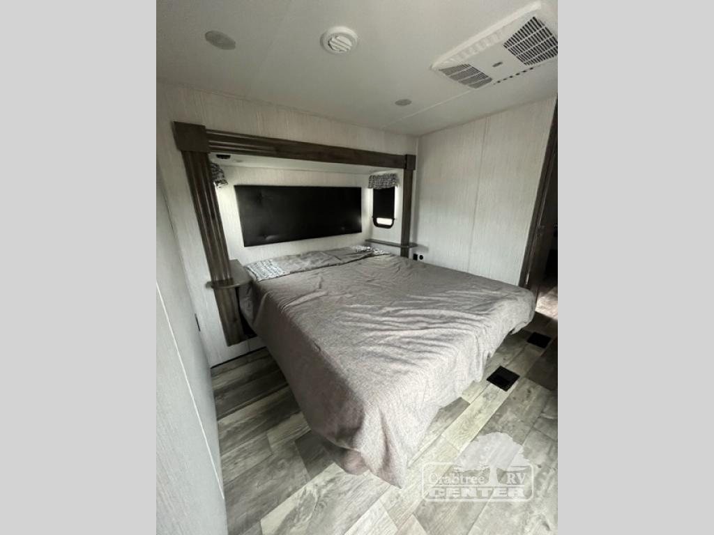 Cozy RV rental bedroom with a comfortable queen-size bed, modern headboard, and AC, ideal for travel comfort.. Forest River Sandpiper 2021