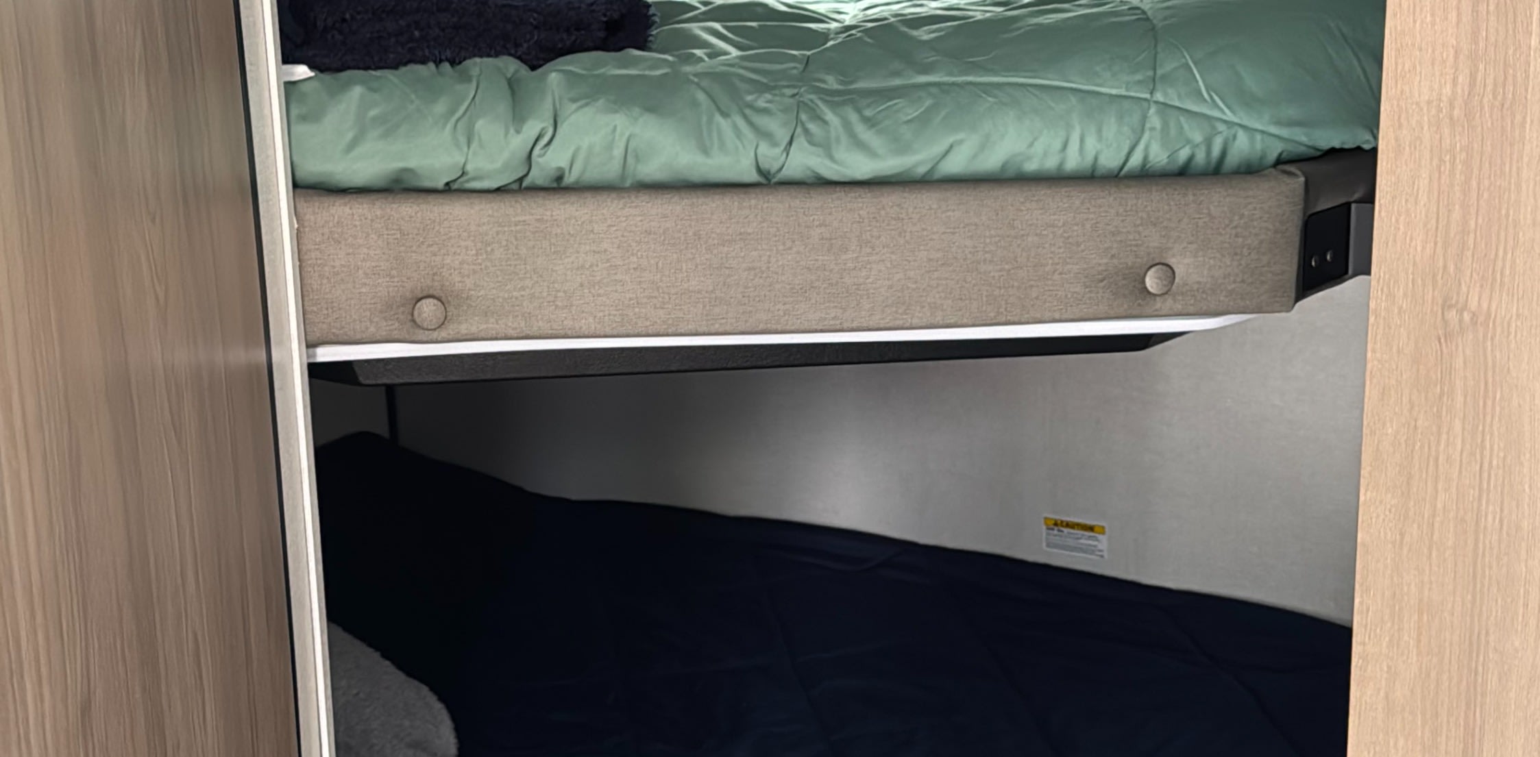RV rental interior: stacked bunk beds with cozy bedding in a compact space, ideal for family travel.. Keystone Coleman 22BX 2025