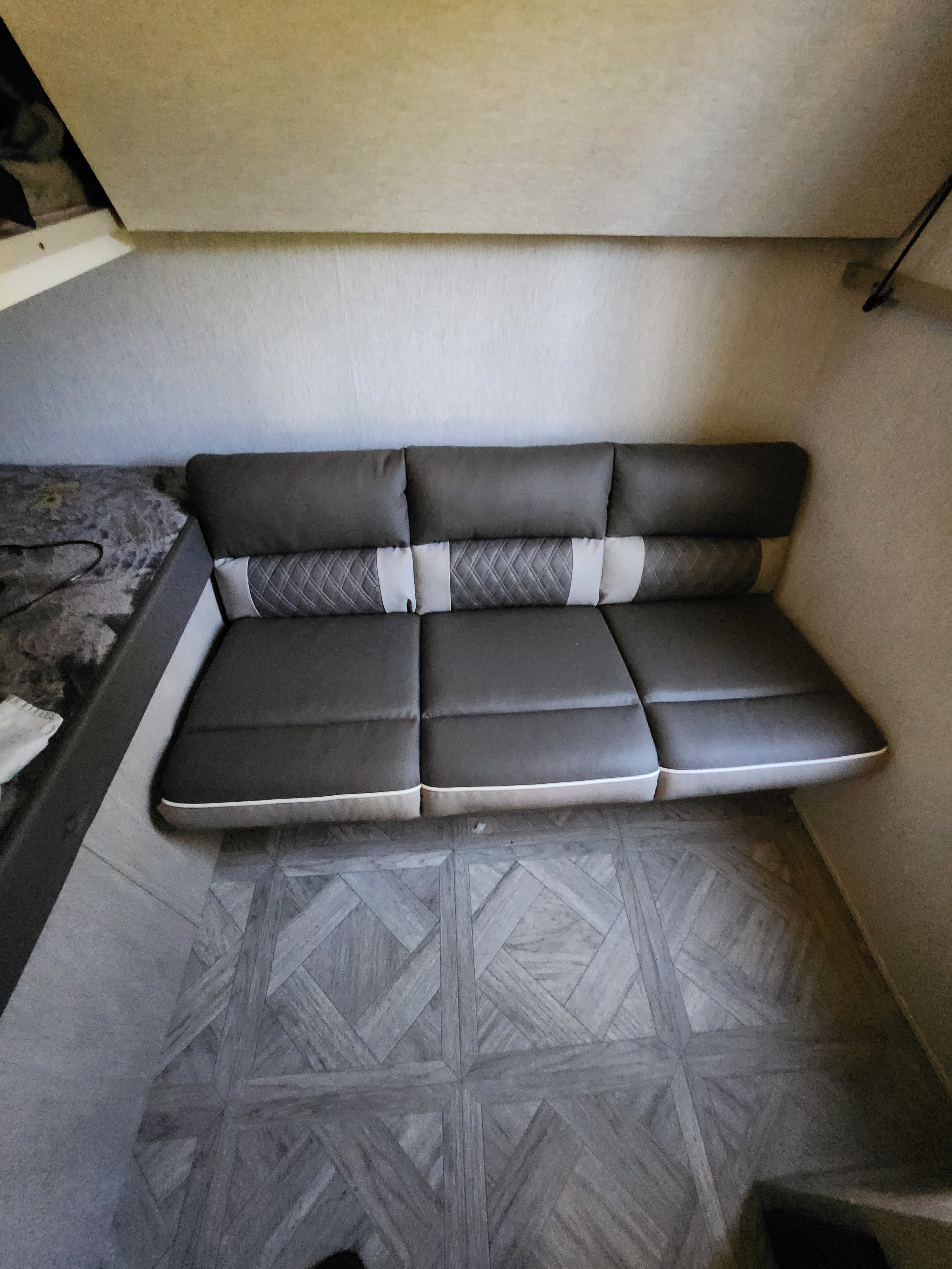 Stylish gray sofa and patterned floor in an RV rental. Cozy interior, ideal for your next adventure.. Forest River Salem Cruise Lite Platinum 2024