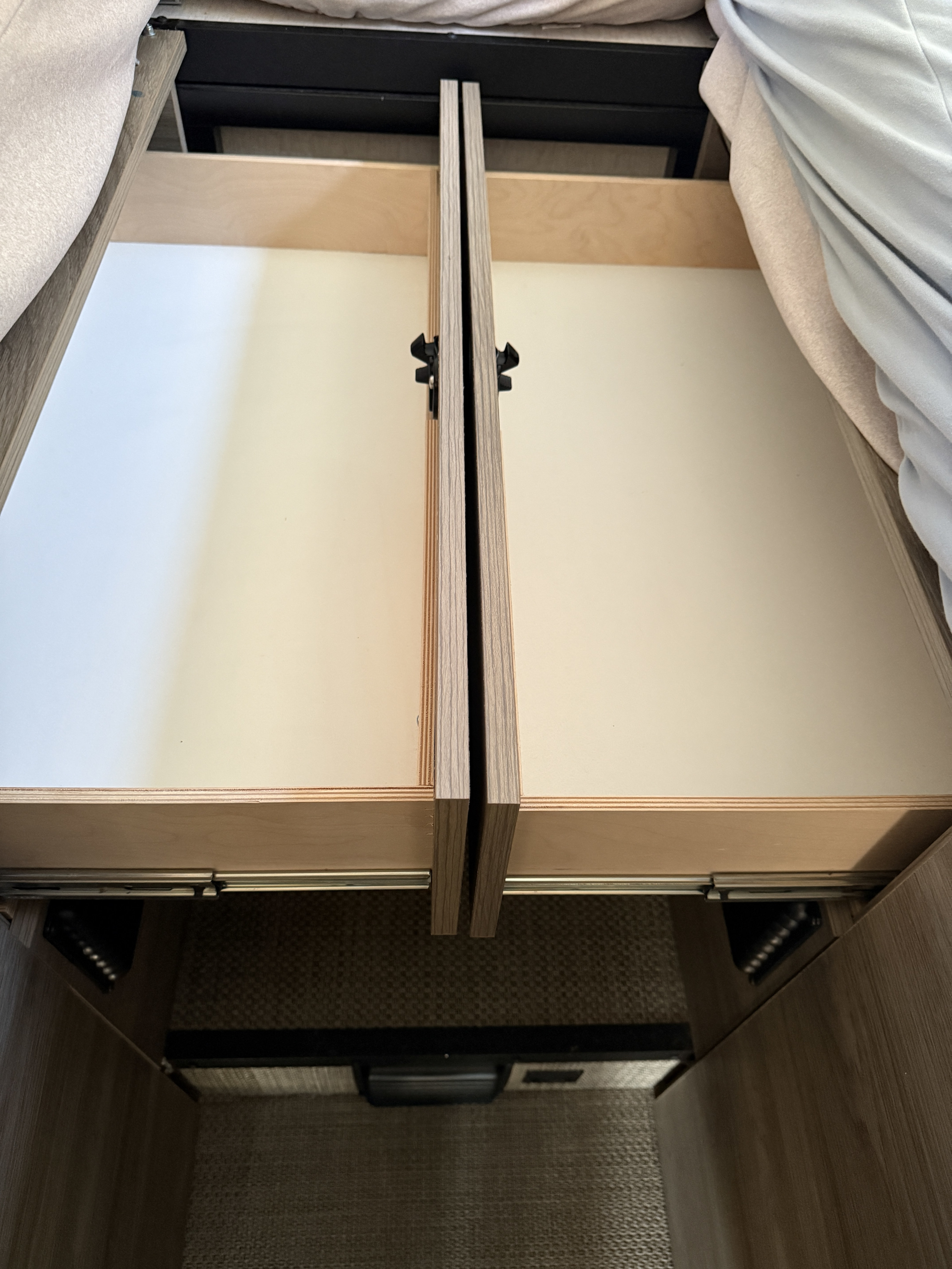 Compact storage in an RV rental: Two open pull-out drawers with latches, ideal for travel organization.. Winnebago Ekko 2025