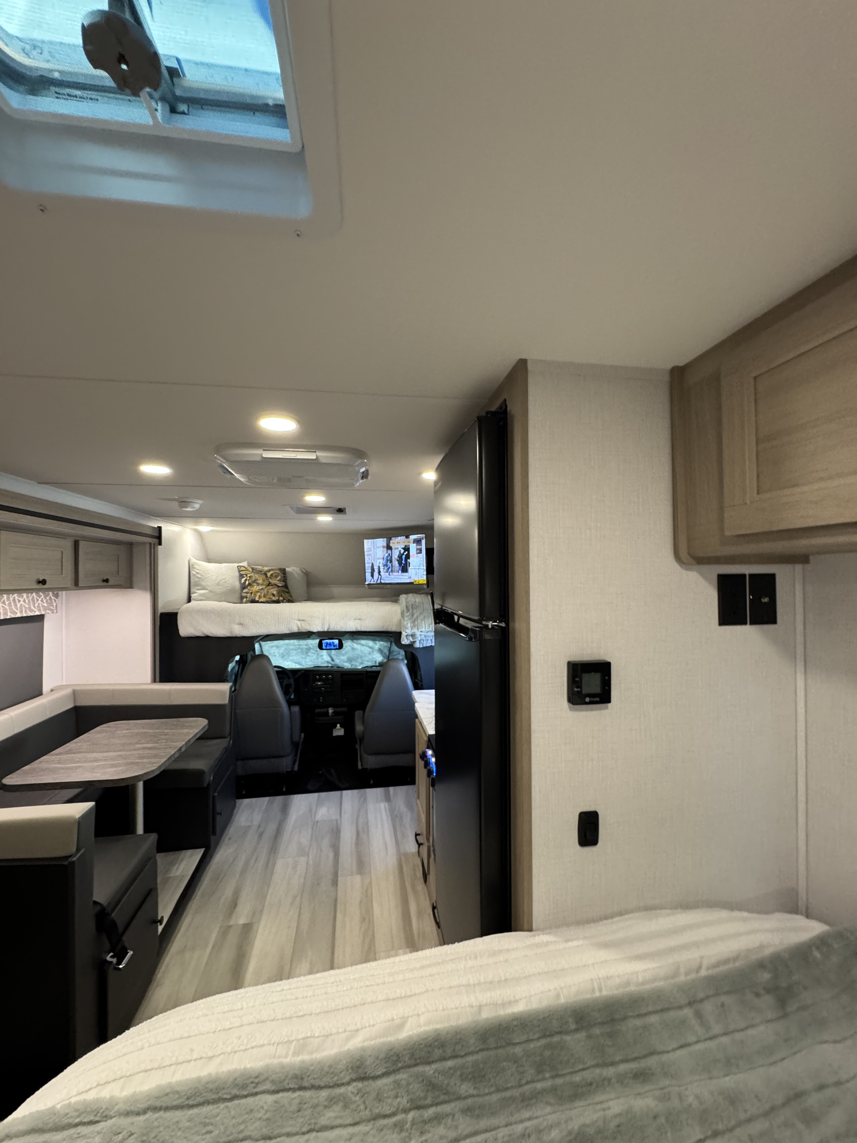 Spacious rv rental interior with a dinette, overhead bunk, kitchenette, and control panel, ready for adventure.. Forest River Sunseeker 2026