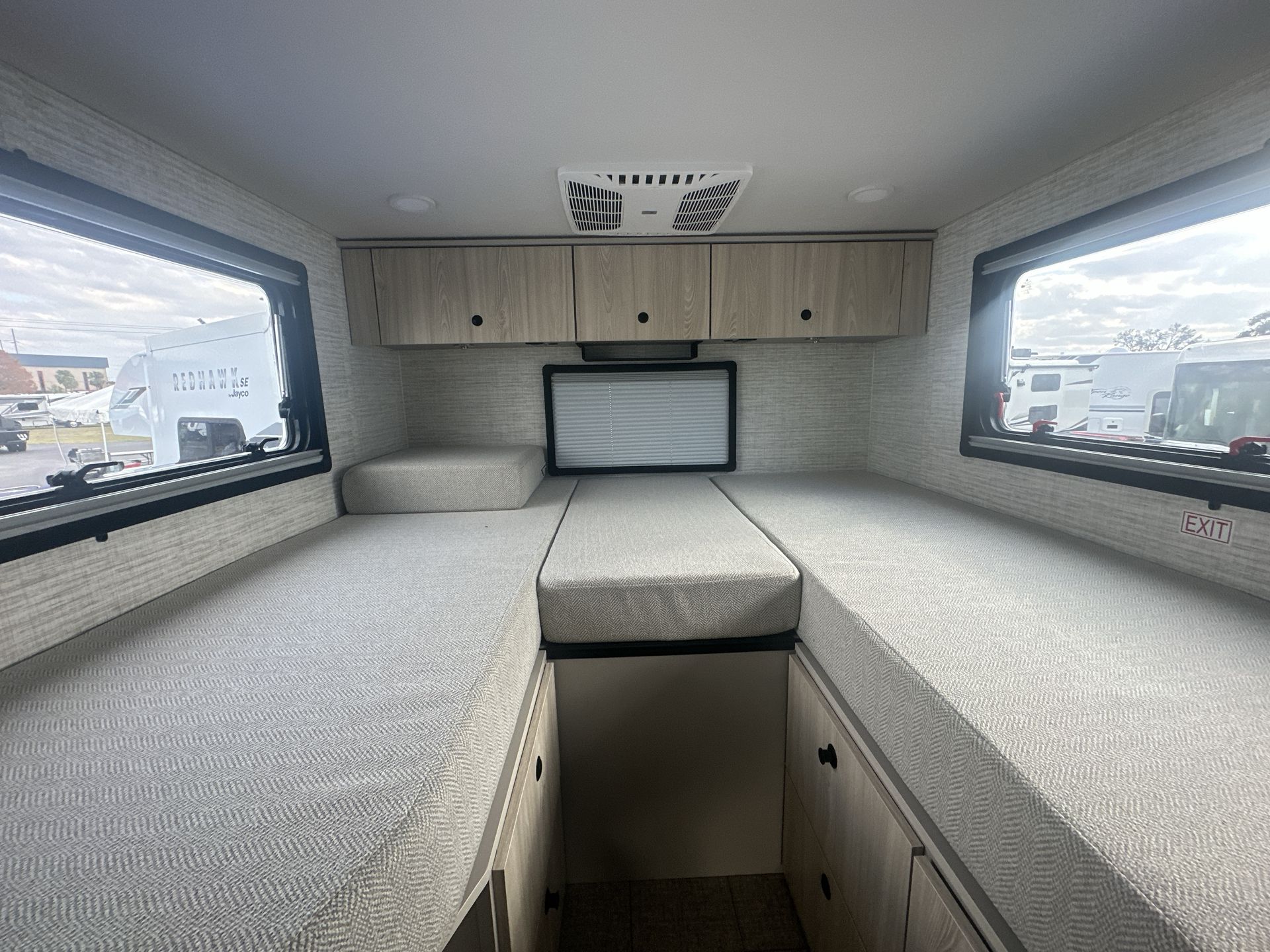 Explore this cozy RV rental interior: flexible sleeping/seating, ample overhead storage, and large windows for a comfortable trip.. Jayco Granite Ridge 2025