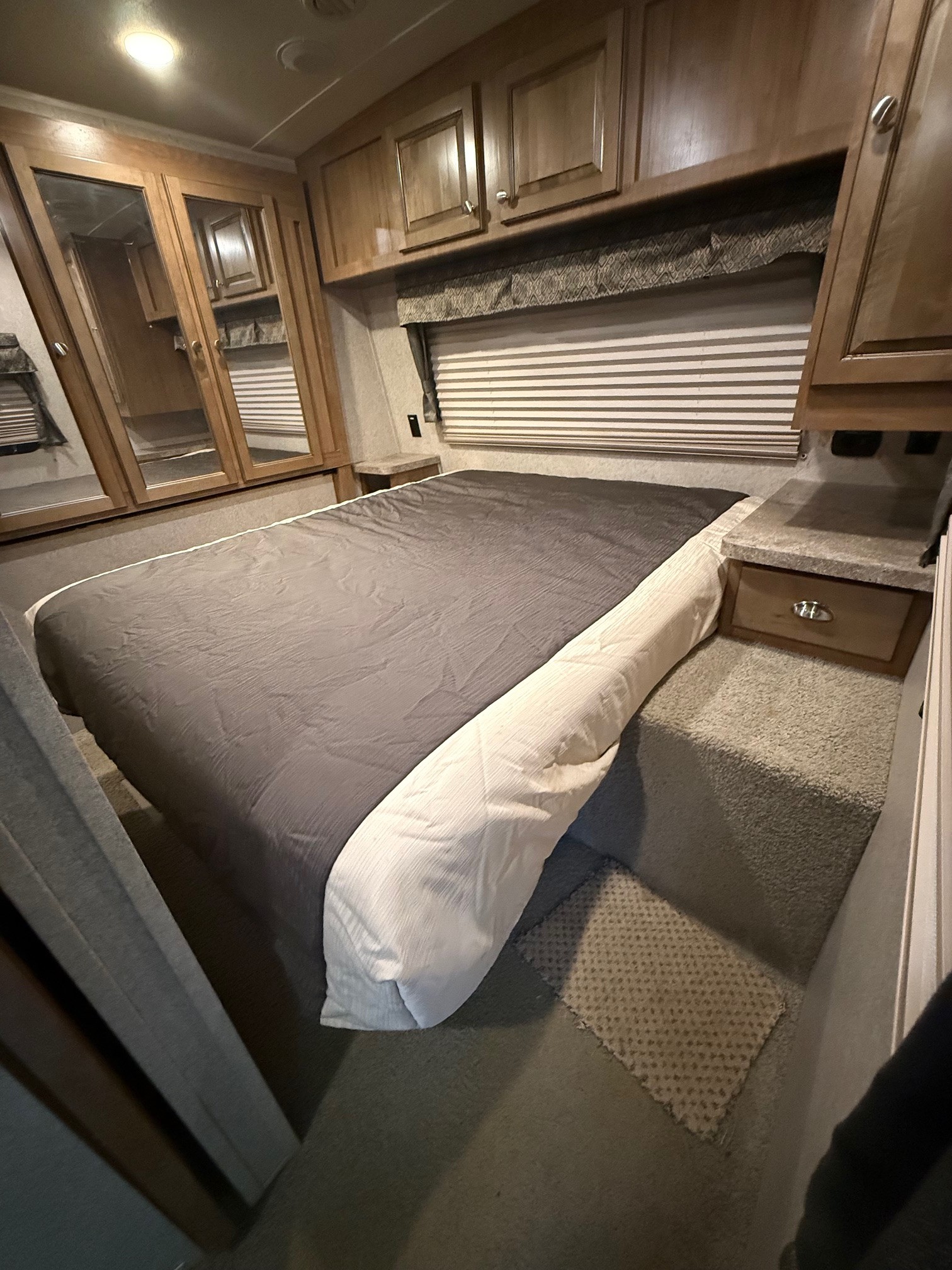 Step into this comfortable RV rental bedroom, featuring a large bed, ample storage, and a cozy window area.. Forest River Flagstaff Classic Super Lite 2017