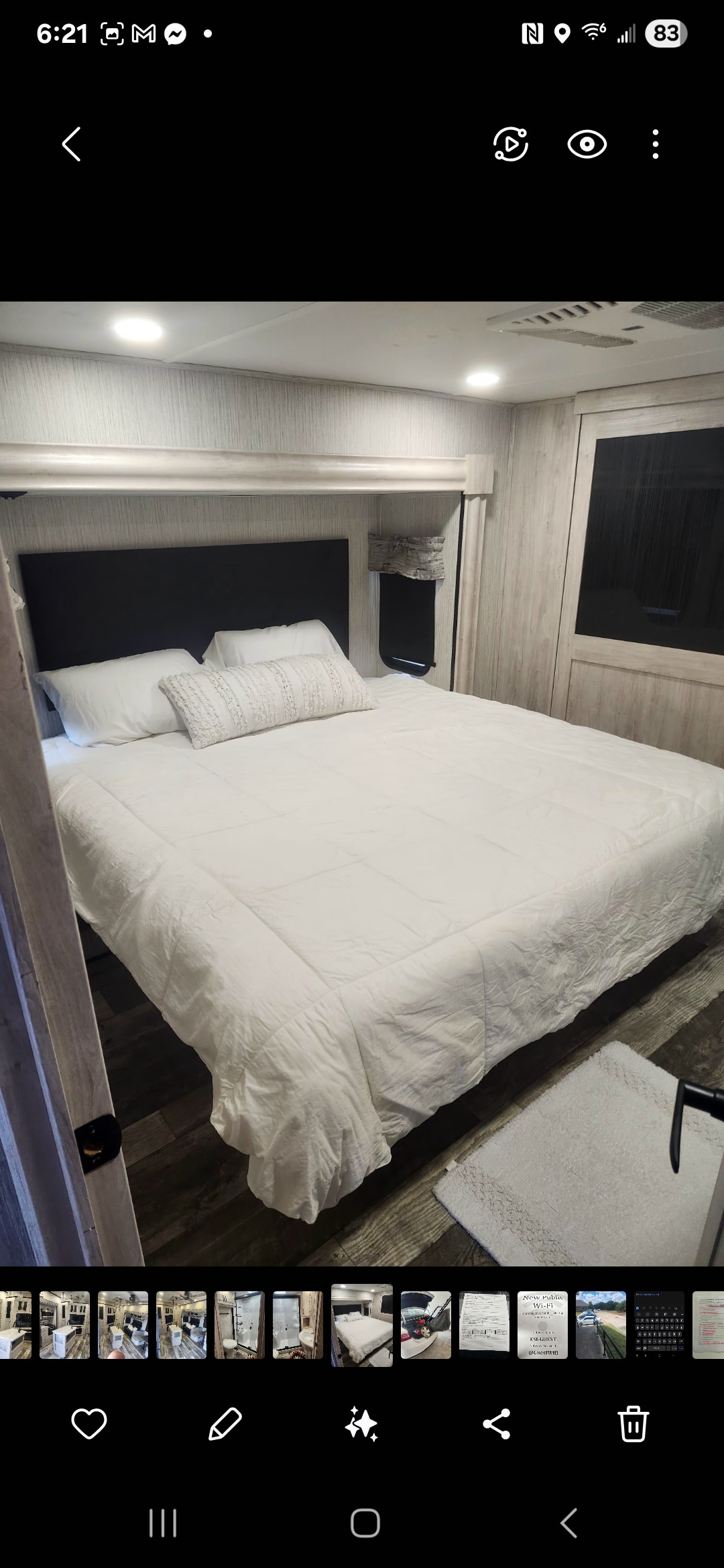 RV rental's cozy bedroom: a large bed with white bedding, dark headboard, and light wood paneled walls.. Forest River Sierra 2023