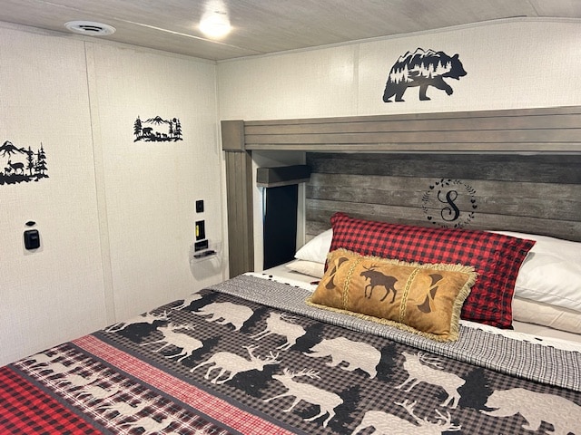 Cozy RV rental bedroom with rustic decor, featuring wildlife bedding and wall decals. Perfect for a nature getaway.. Keystone RV Cougar 2022