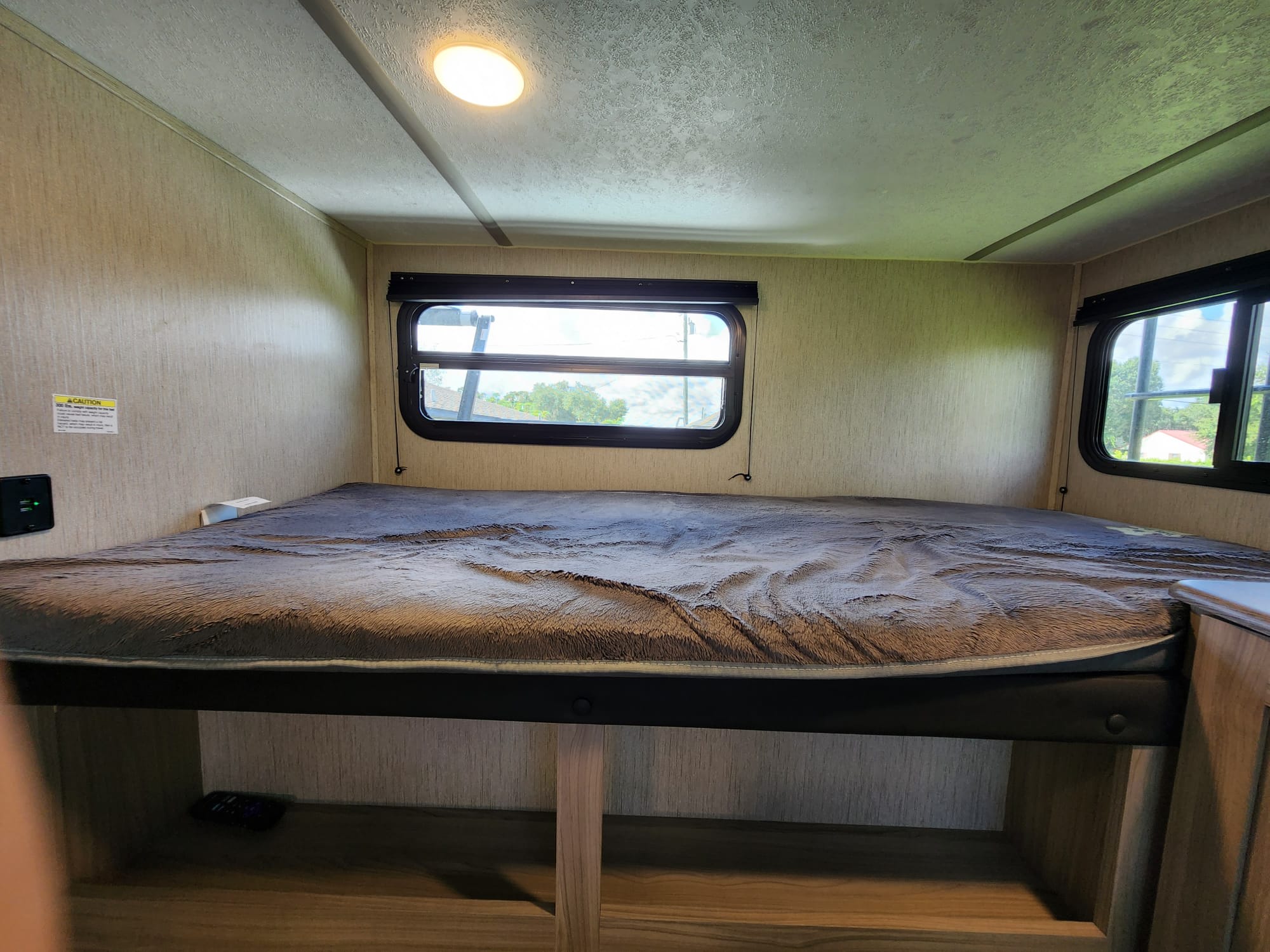 Cozy RV rental bunk bed with windows and USB charging, offering a comfortable sleeping area for travel.. Coachmen 292BHDS 2021