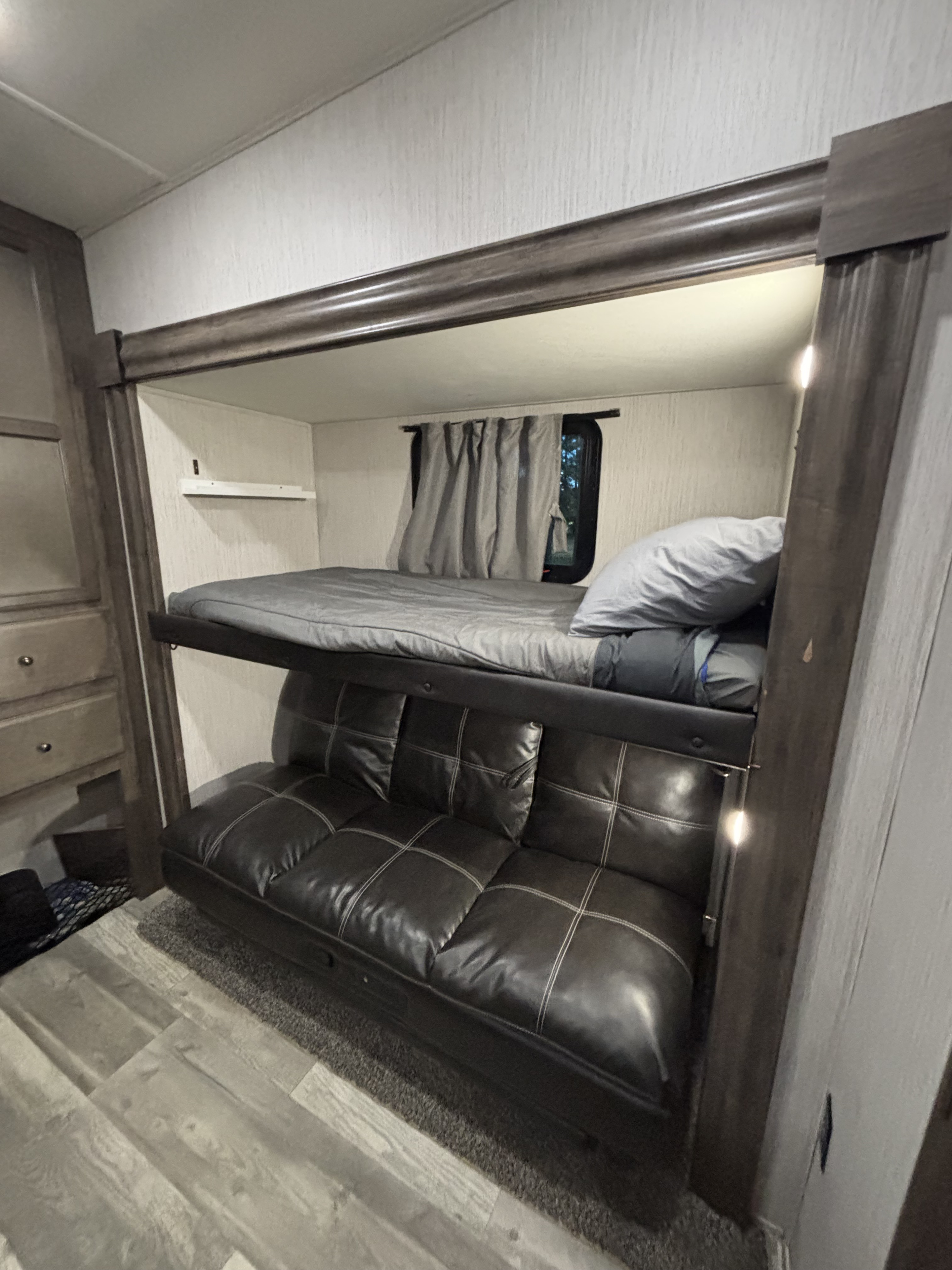 RV rental interior featuring bunk beds and a futon sleeping area. Ideal for compact and cozy travel accommodations.. Forest River Sandpiper 2021