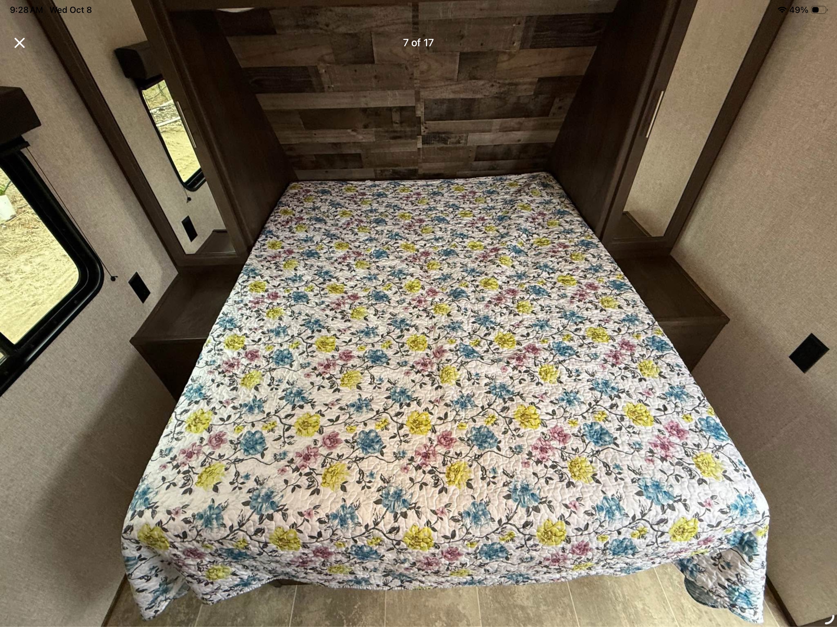 RV rental interior: bedroom with a bright floral quilt, wood-paneled wall, and convenient side shelves.. Aspen Trail 2180RDWE 2020