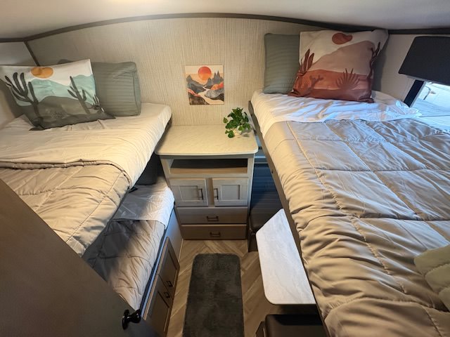 This RV rental features comfortable bunk beds, each with cozy bedding and desert-themed pillows, creating a welcoming sleep space.. Cruiser RV Shadow Cruiser 2021