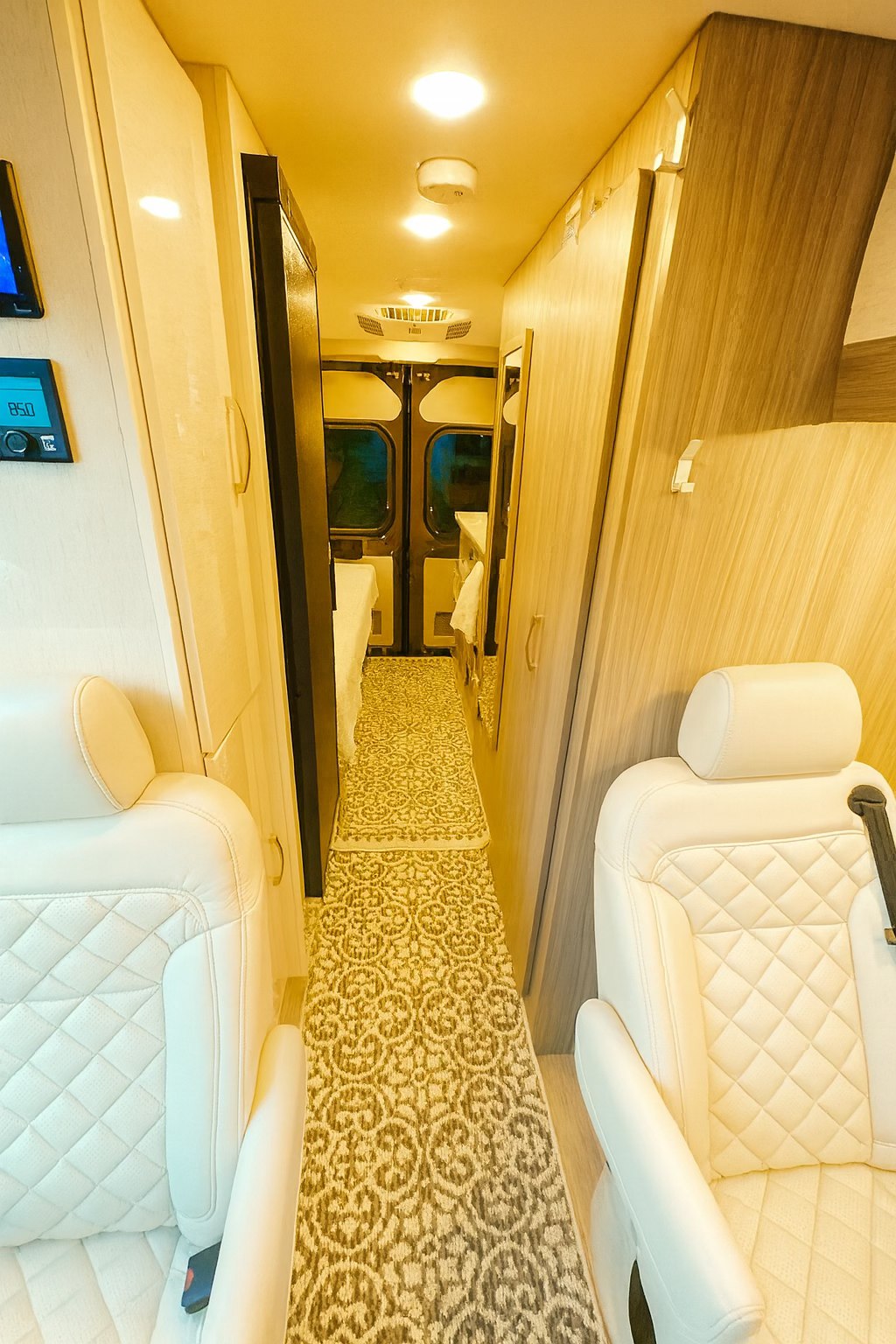 RV rental: Bright, modern interior shows a hallway with white quilted seats, light wood cabinets, and a patterned floor runner.. Jayco Swift 2023