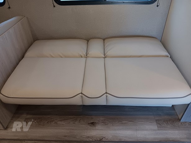 RV rental: Cream-colored convertible sofa bed with gray piping and wood flooring, ready for a restful sleep.. Other Catalina 2025
