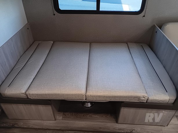 Flexible RV rental dinette converts to a bed, offering practical seating and sleeping options with under-seat storage.. Other Catalina 2025