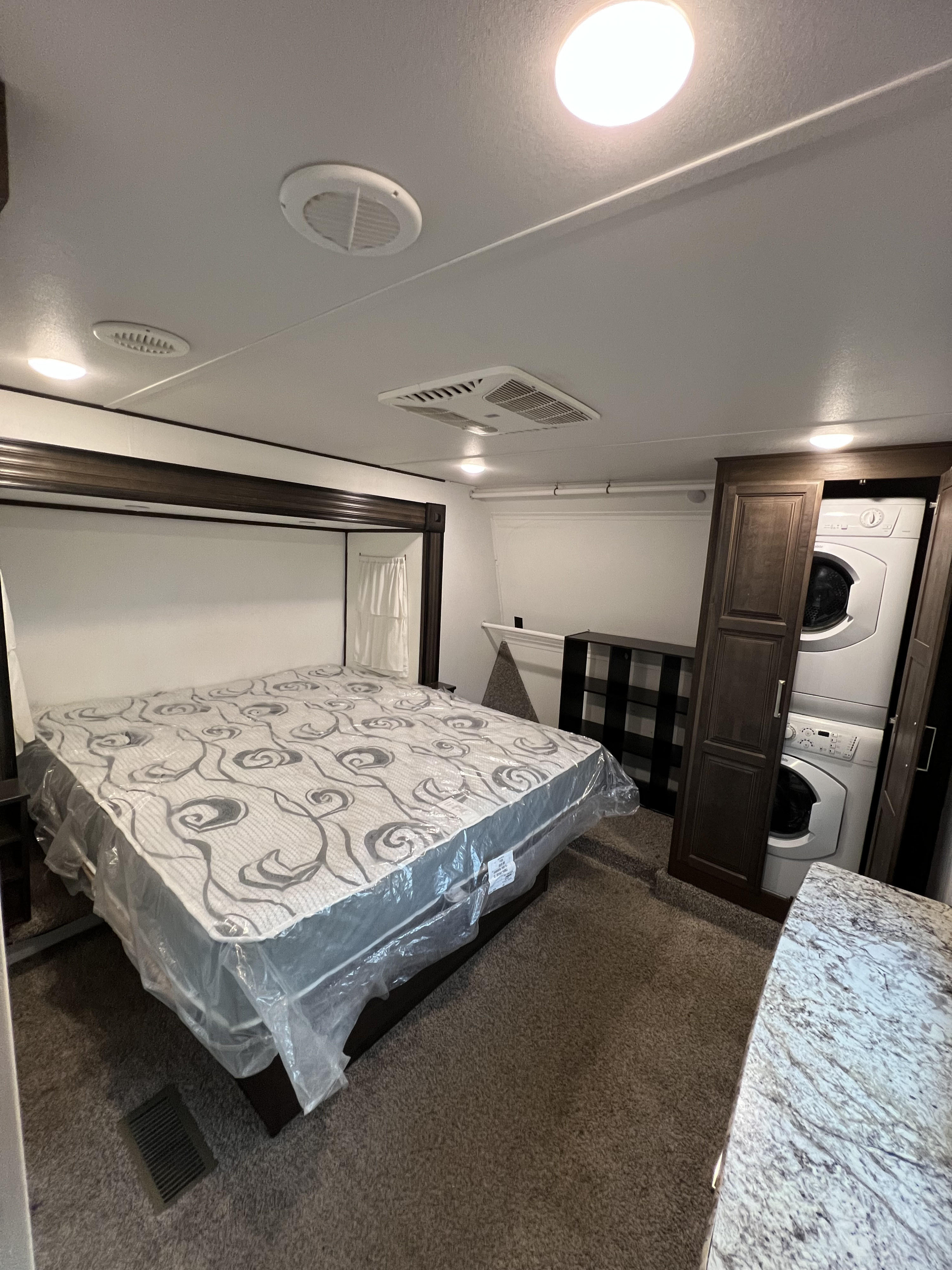 RV rental: Bright bedroom with a bed, built-in washer/dryer, and ceiling AC, offering home-like comfort on the go.. Keystone RV Avalanche 2019