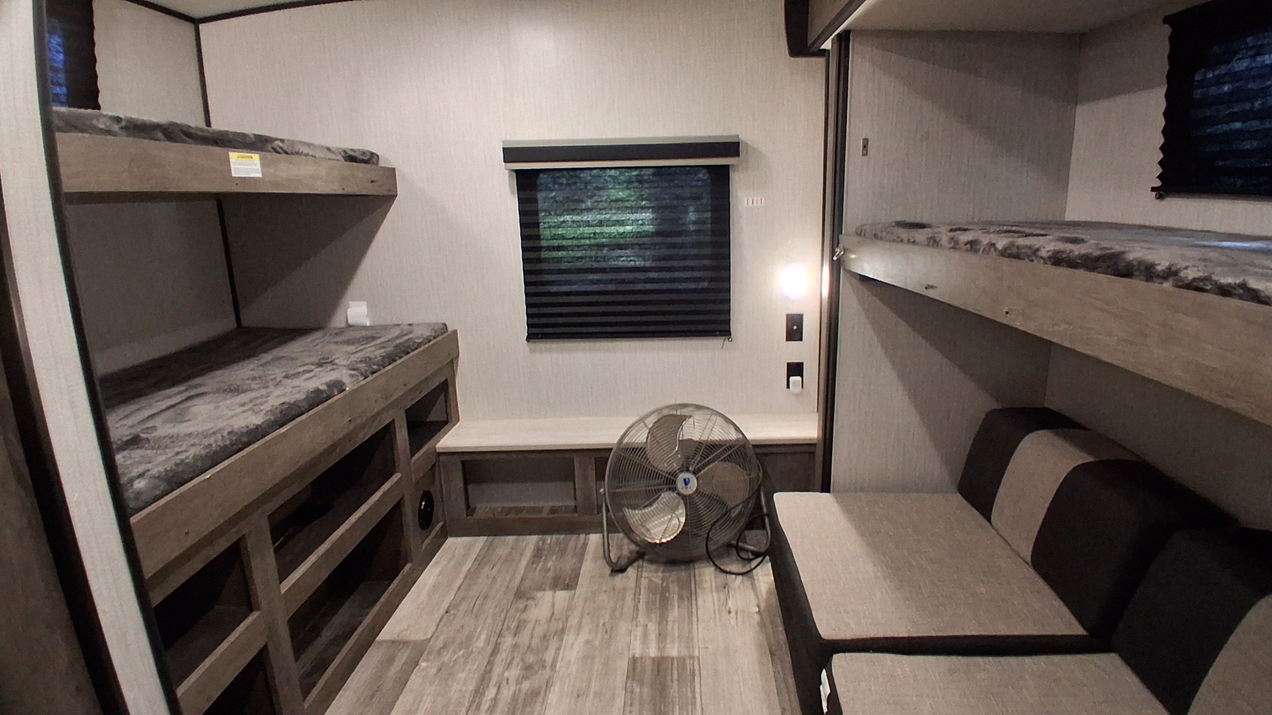 RV rental interior shows bunk beds, a dinette, window with blinds, and a fan in a compact living space.. Heartland RVs North Trail 2021