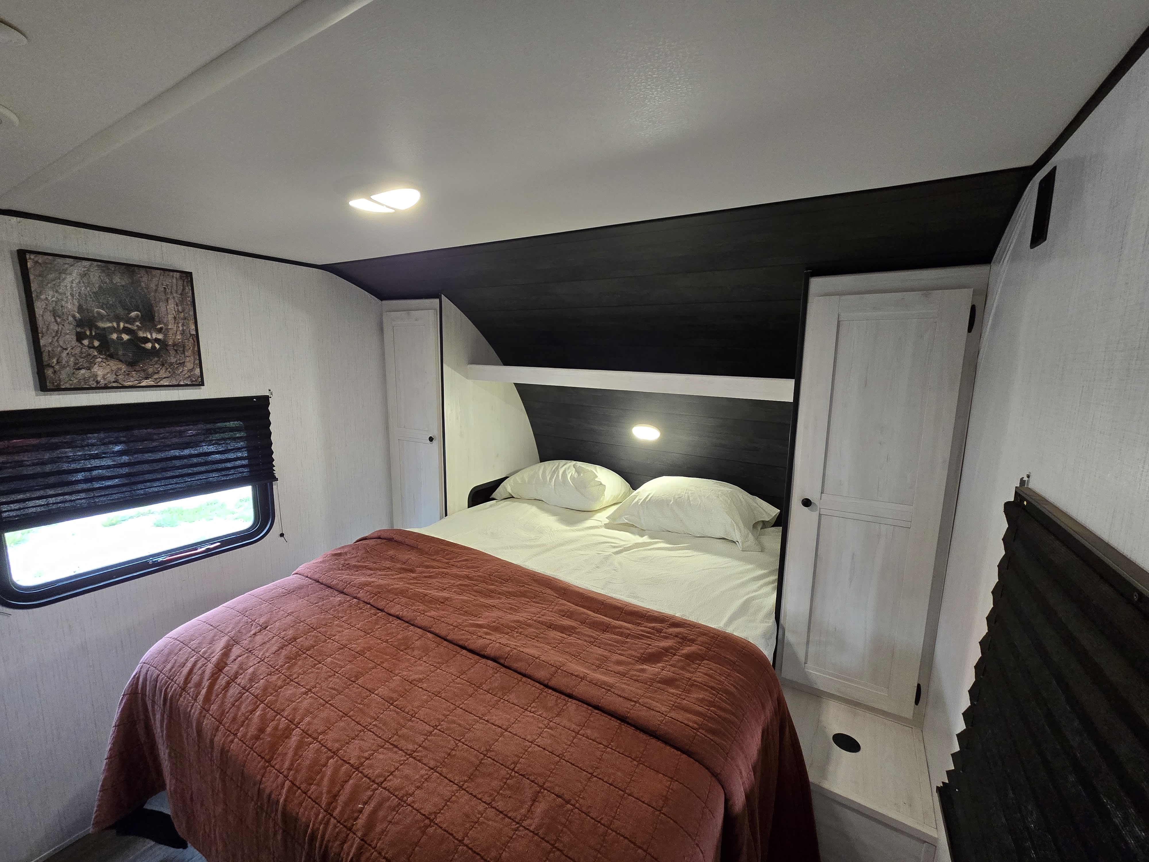 Cozy RV rental bedroom with a comfy bed, overhead storage, light, and window, perfect for your next adventure.. Heartland RVs Trail Runner 2022