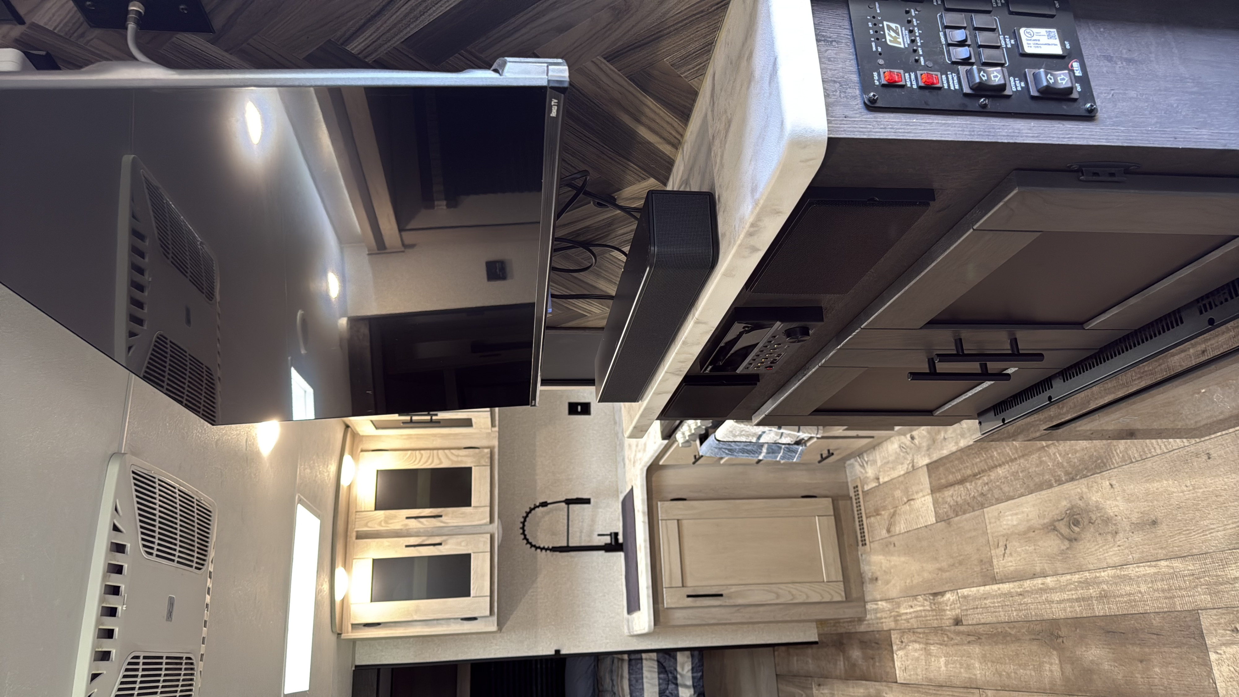 Modern rv rental interior features a Roku TV, soundbar, control panel, and light wood cabinetry, showcasing a comfy living space.. KZ C261RB 2021