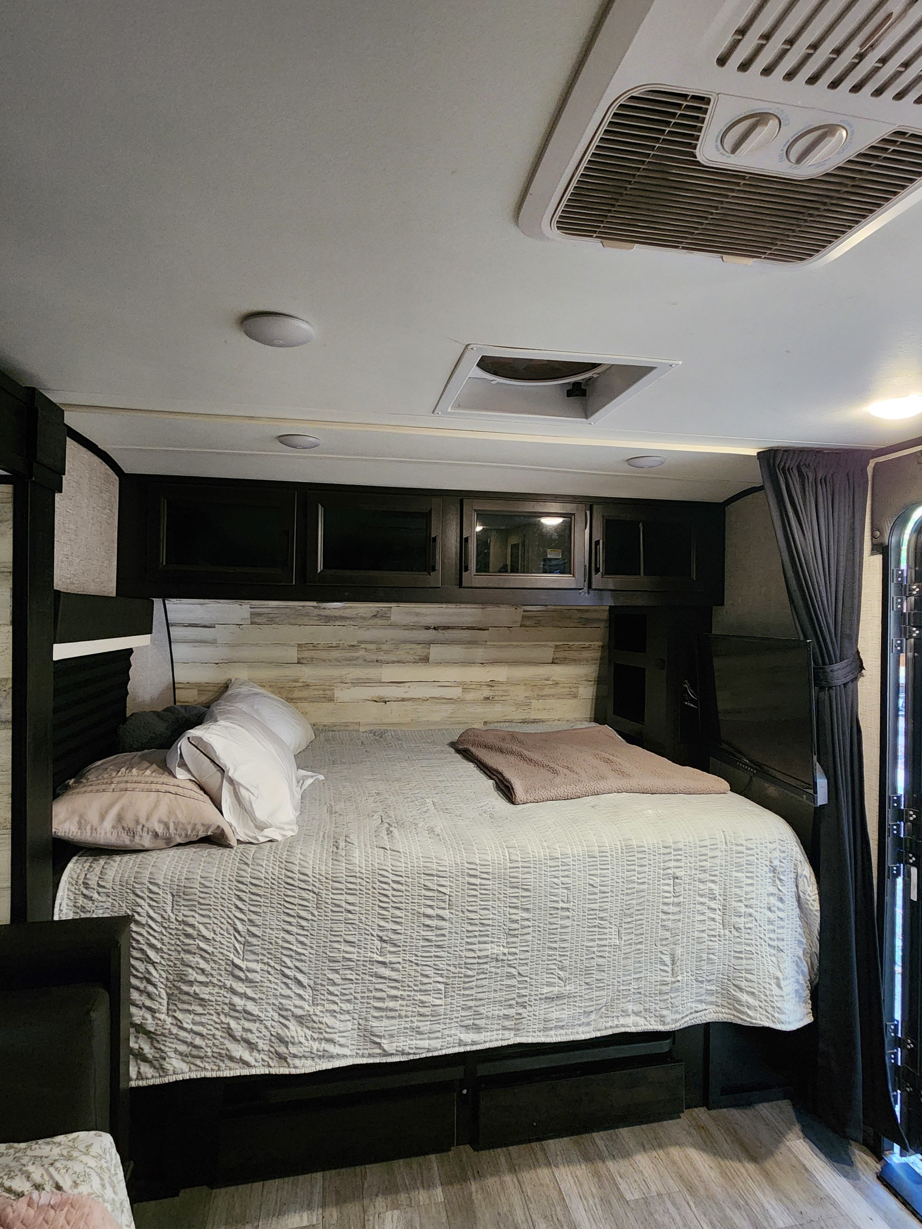 Cozy RV rental bedroom with comfortable bed, overhead storage, and AC for a relaxing stay.. Jayco Jay Feather Micro 2022