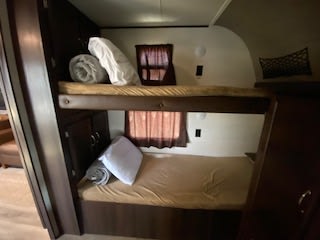 Cozy RV rental sleeping nook: two brown-bedded bunk beds with pillows, ideal for camping adventures.. Jayco Jay Flight 2018