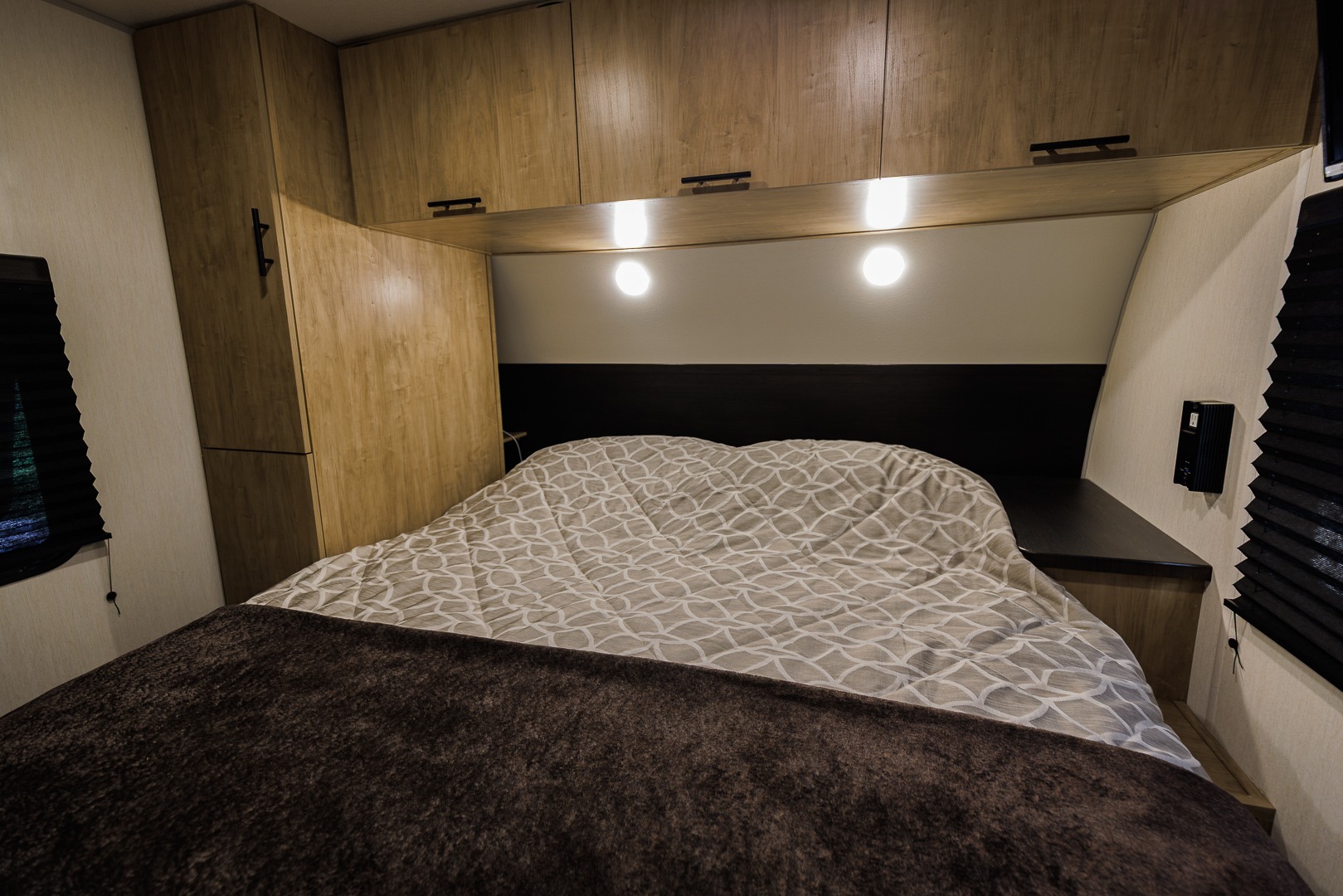 RV rental interior: a well-appointed bedroom with a plush bed, wooden cabinets, and integrated lighting for comfort.. Forest River Cherokee Grey Wolf 2026