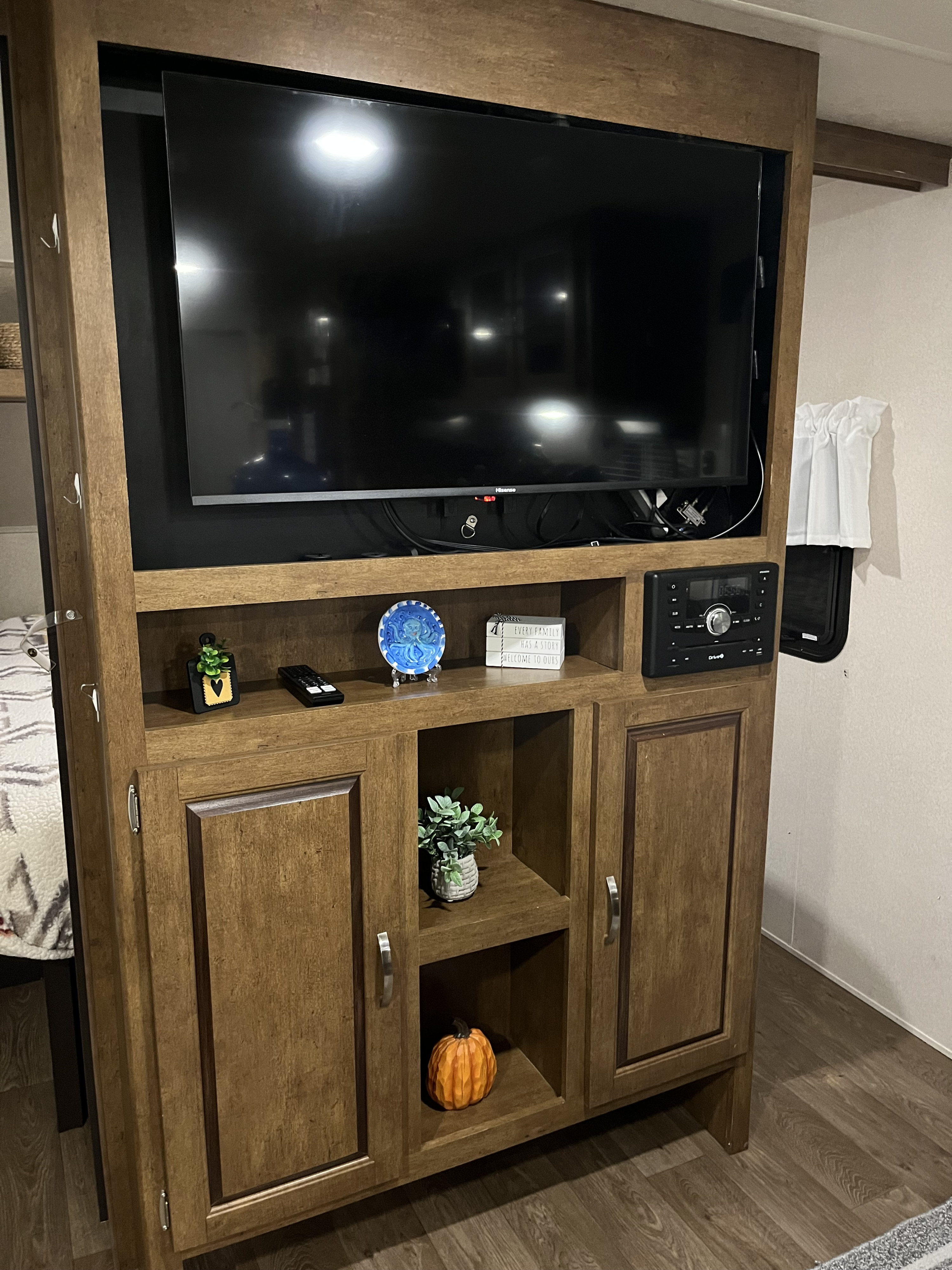 This RV rental features a cozy interior with a TV, decorative wooden entertainment center, and audio unit for your travels.. Forest River Wildwood X-Lite 2018