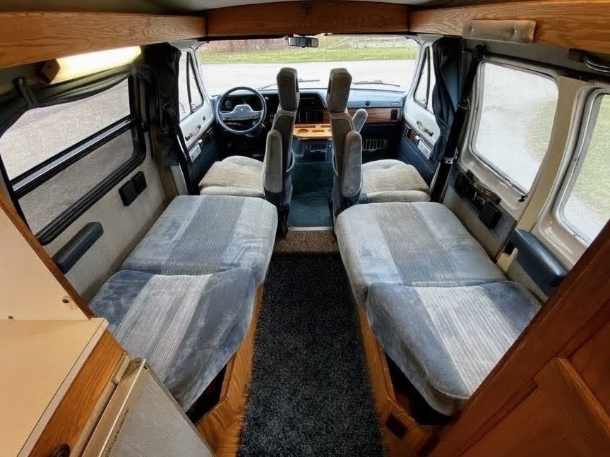 RV rental: Inside a camper van, showing dual bench seats, narrow aisle, and front cabin view.. Roadtrek 190 Versatile 1996