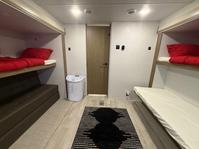 This clean RV rental bunk room offers multiple beds and a modern design, perfect for family adventures.. Forest River Wildwood 2025