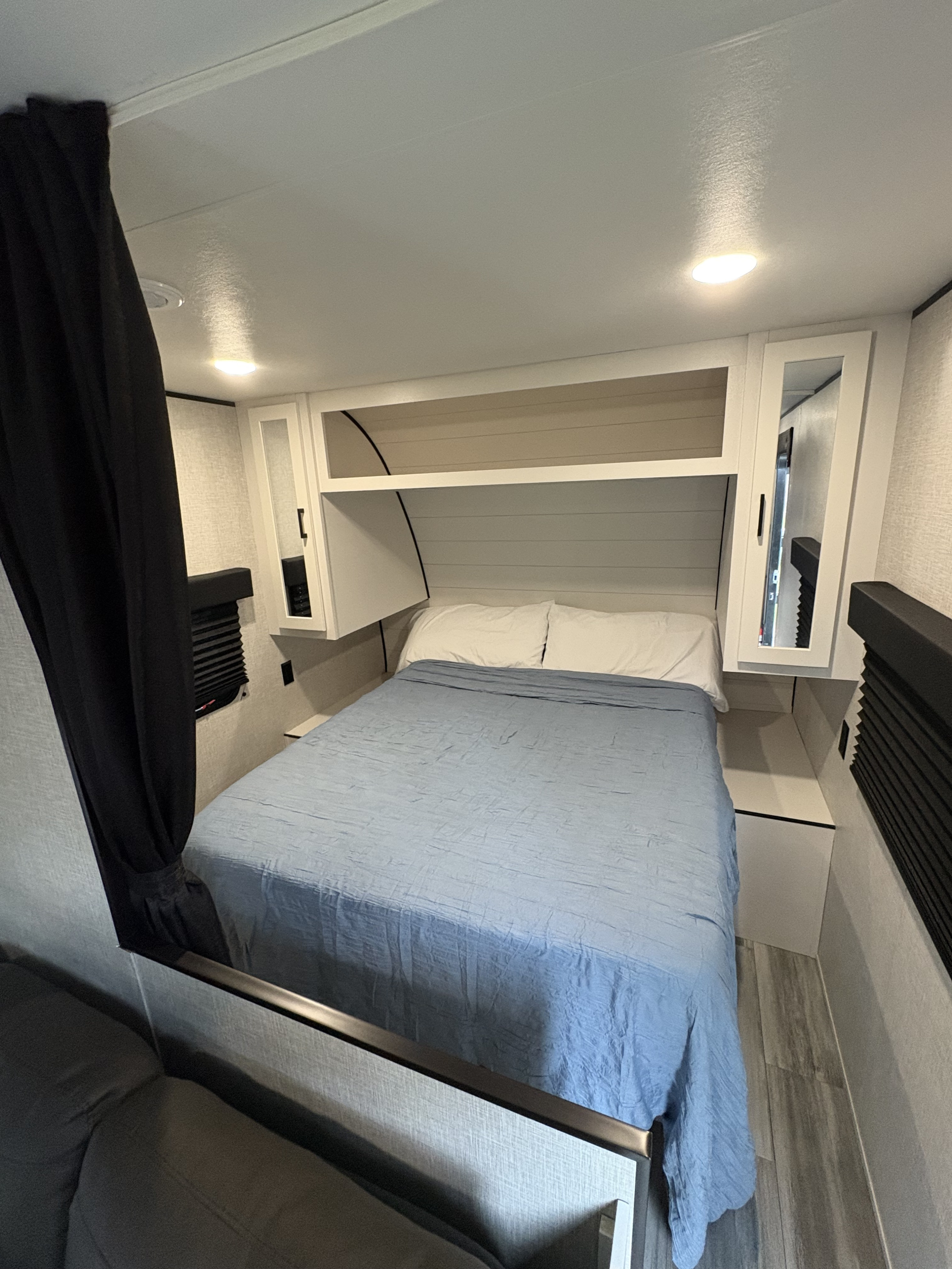 Modern RV rental bedroom featuring a cozy bed, white pillows, overhead storage, and ceiling lights. Ideal for travel comfort.. Jayco Jay Flight SLX 2024