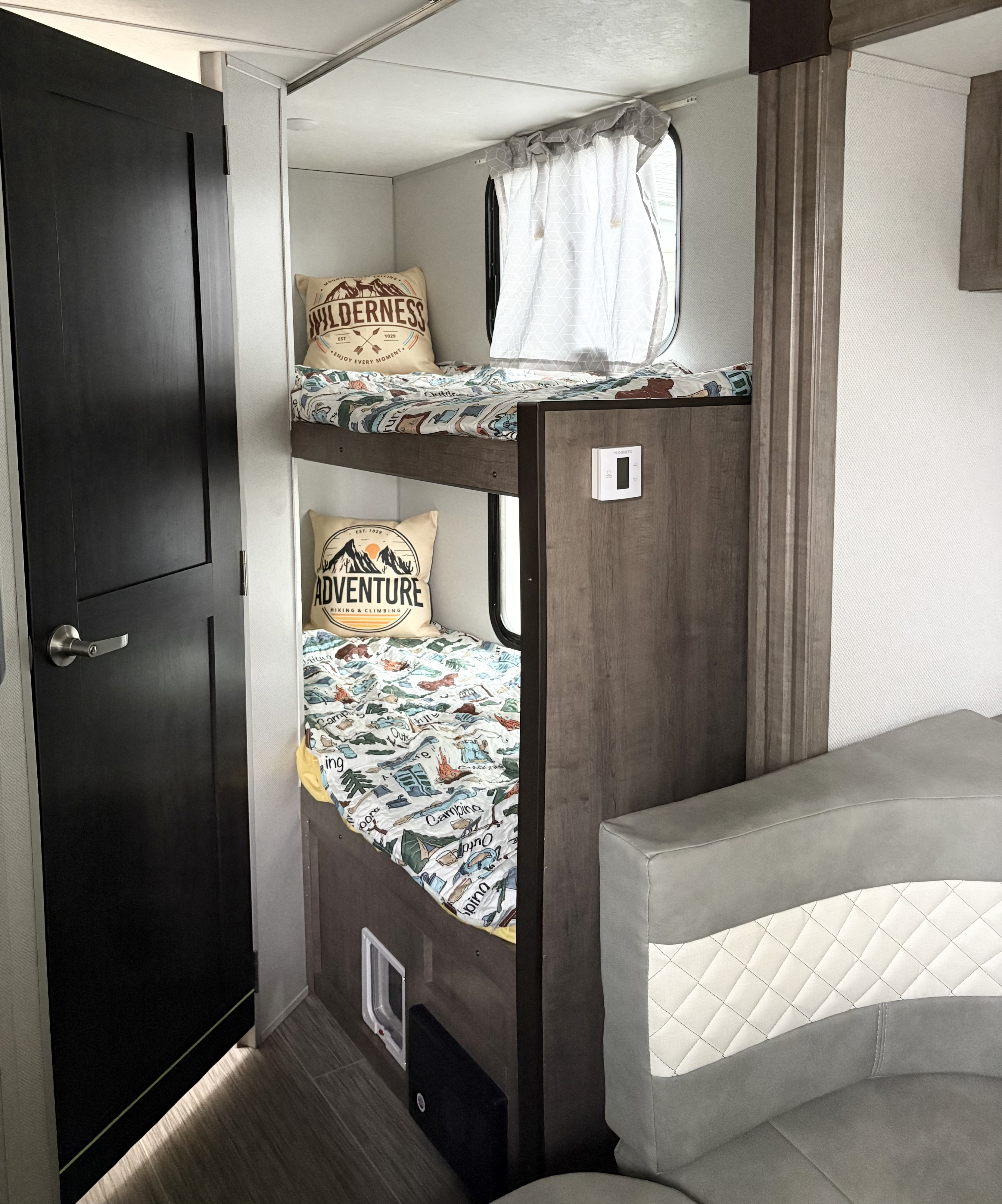 Cozy RV rental interior with adventure-themed bunk beds, ideal for family camping.. No Boundaries 19 2020
