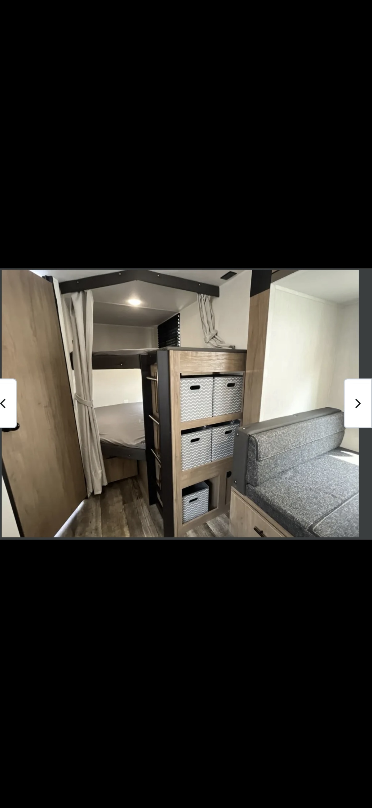 RV rental: Bunk beds, chevron storage bins, and comfy sofa. A compact, functional camper interior with wood-look flooring.. Forest River Campsite Reserve 2025