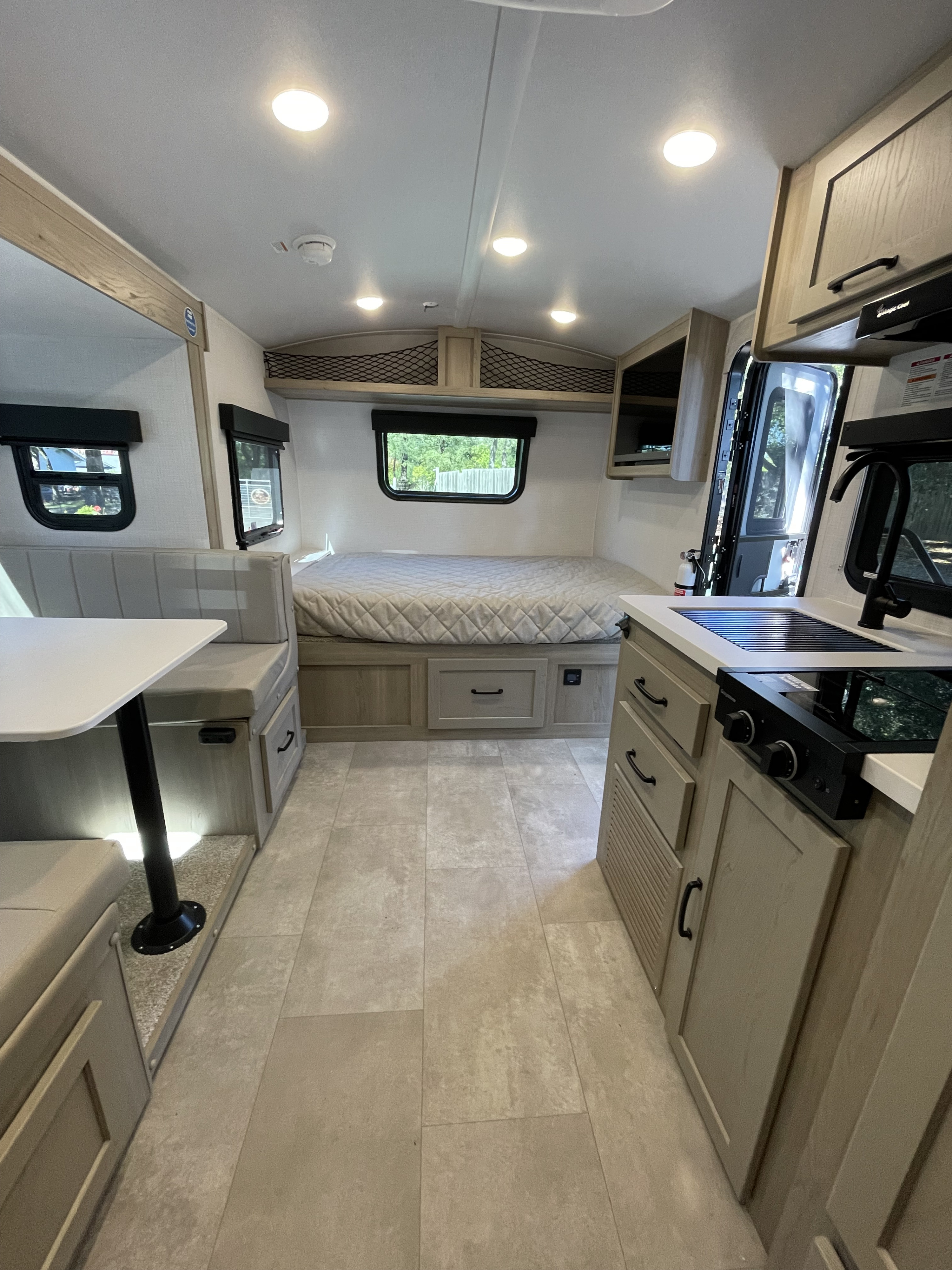 Inside this modern RV rental: a compact kitchen, dinette seating, and comfortable bed for your next adventure.. Forest River Rockwood Geo Pro 2025