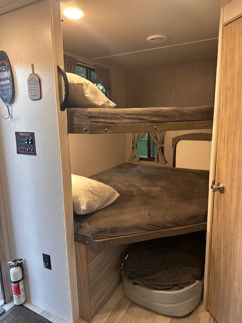 Inside a cozy rv rental: twin bunk beds, pet sleeping area, & safety essentials for family travel.. Winnebago Minnie 2022
