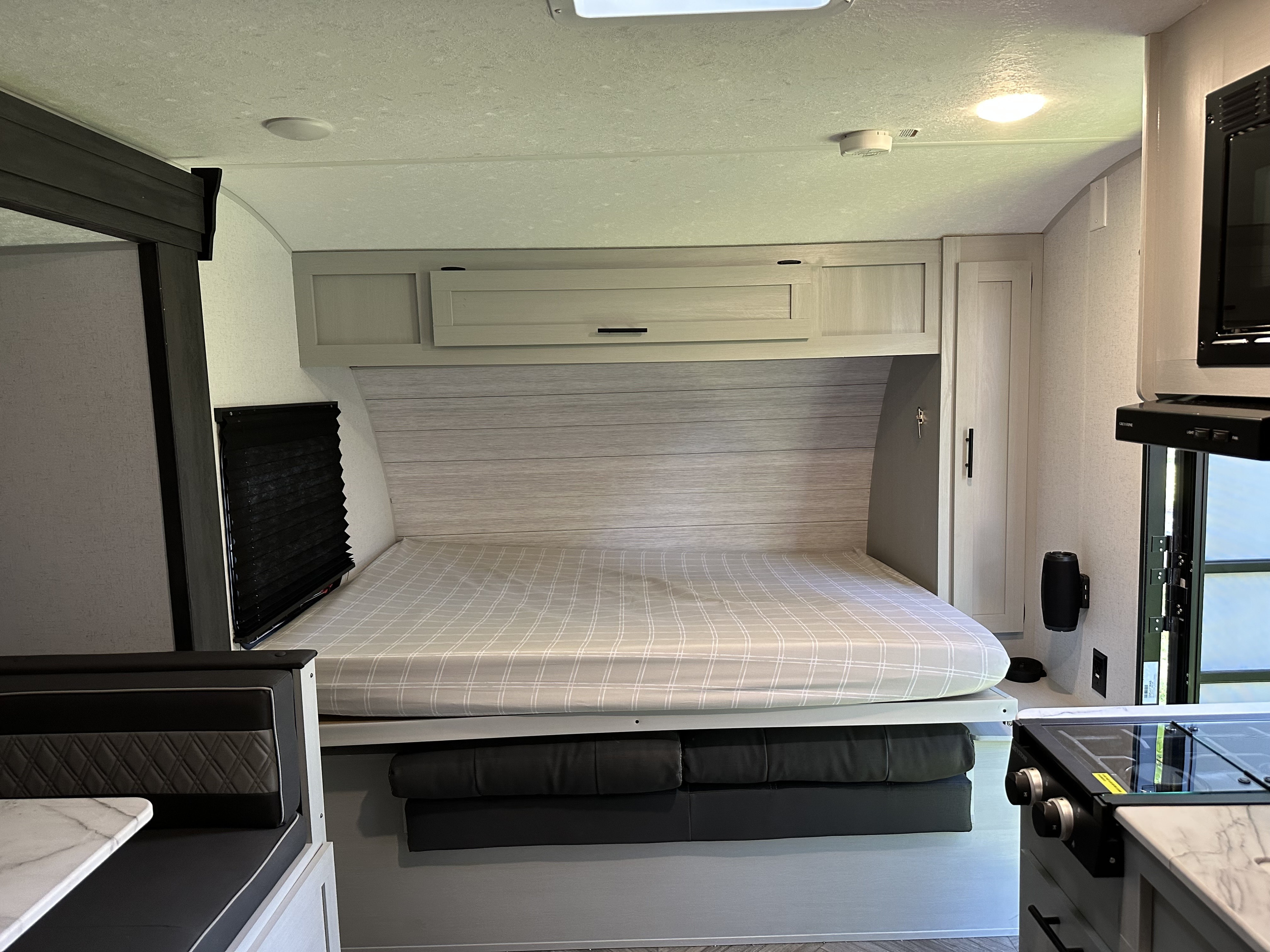 Modern RV rental interior featuring a versatile convertible bed with storage, compact kitchen, and dinette for efficient living.. Forest River Salem FSX 2022
