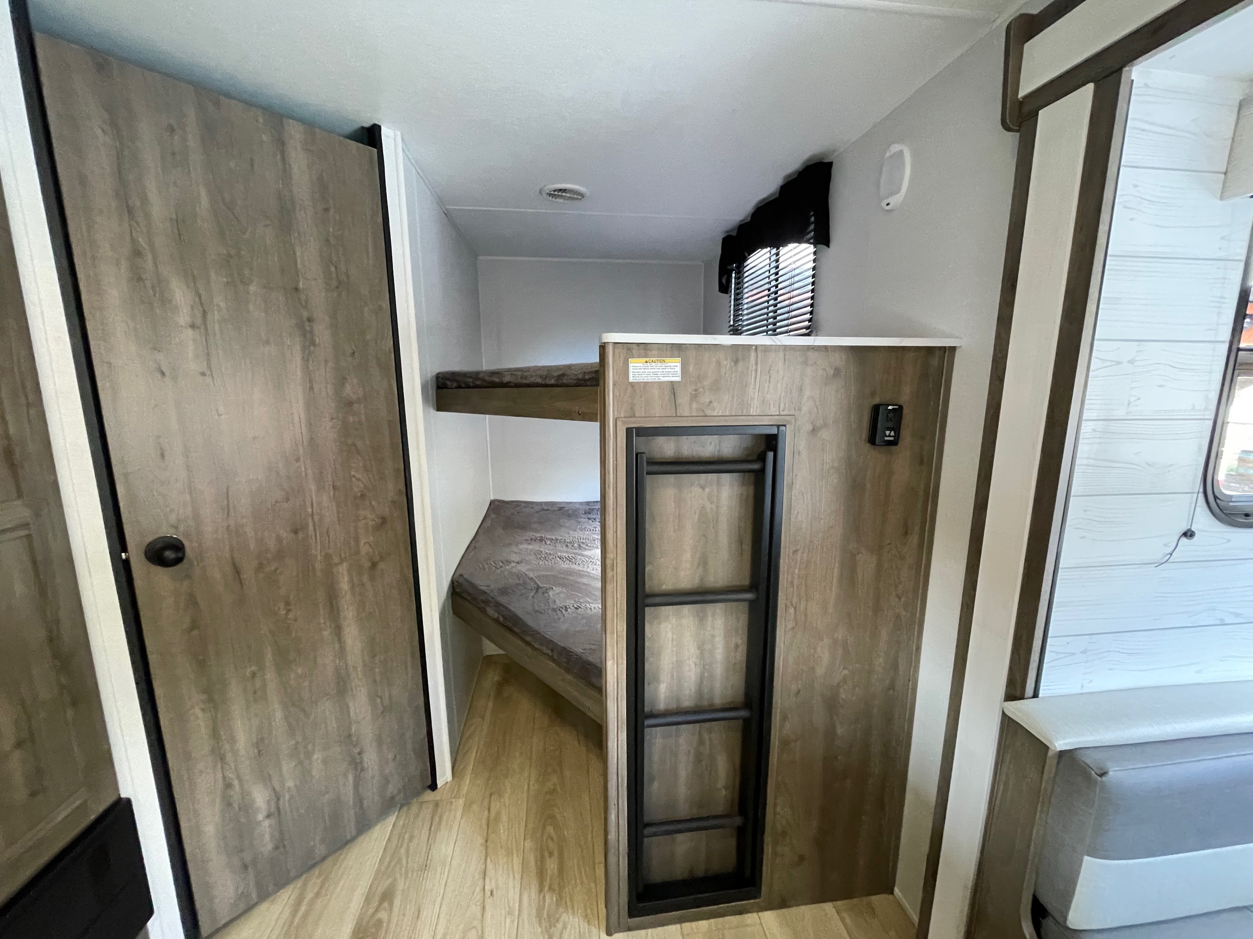 RV rental interior: Bunk beds with a ladder, offering a compact and functional sleeping area in this travel trailer.. Heartland Pioneer 2024