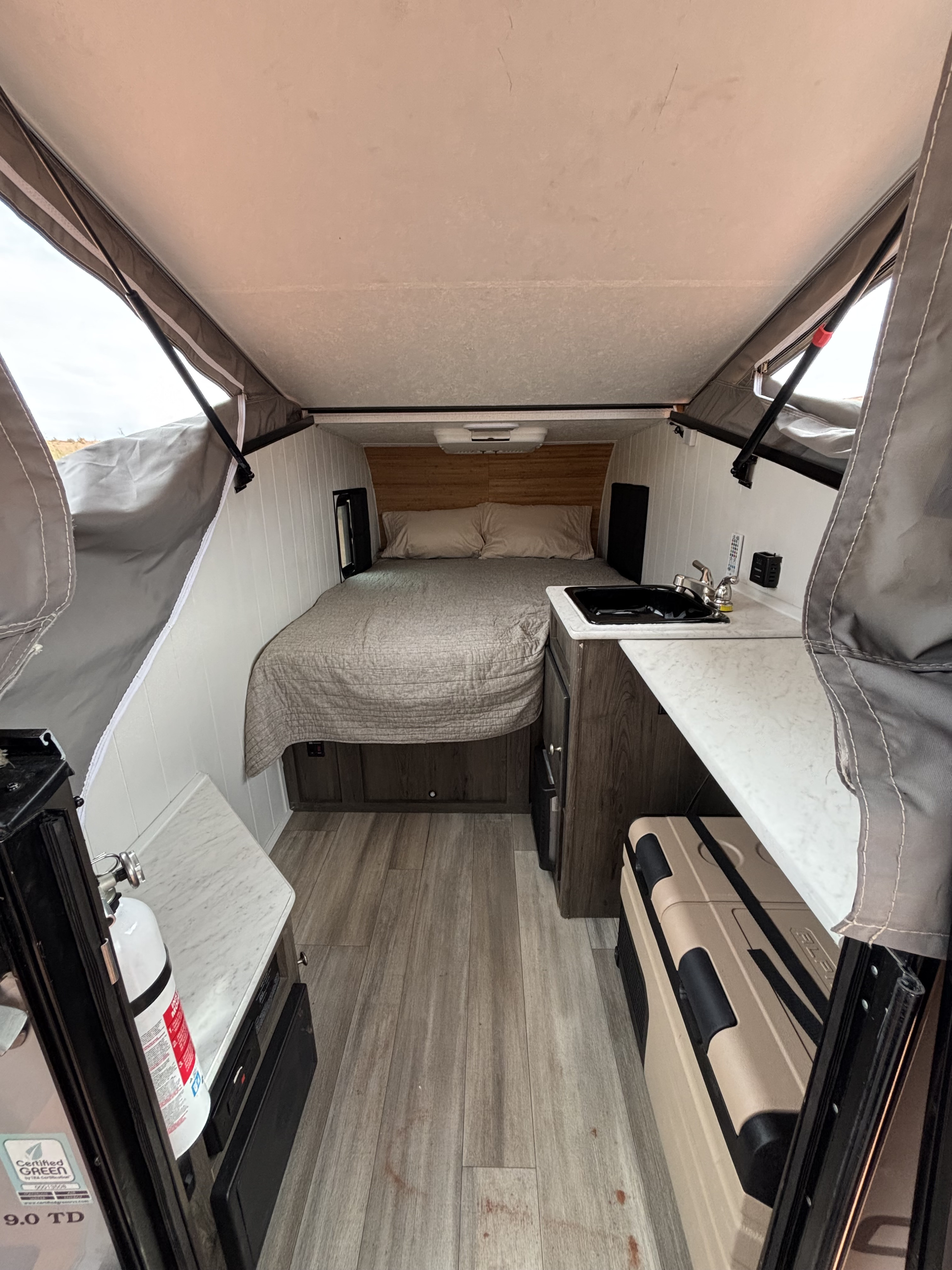 RV rental: a cozy pop-up camper interior with bed, kitchen sink, counter, and cooler for adventures.. Forest River Viking TD 2022
