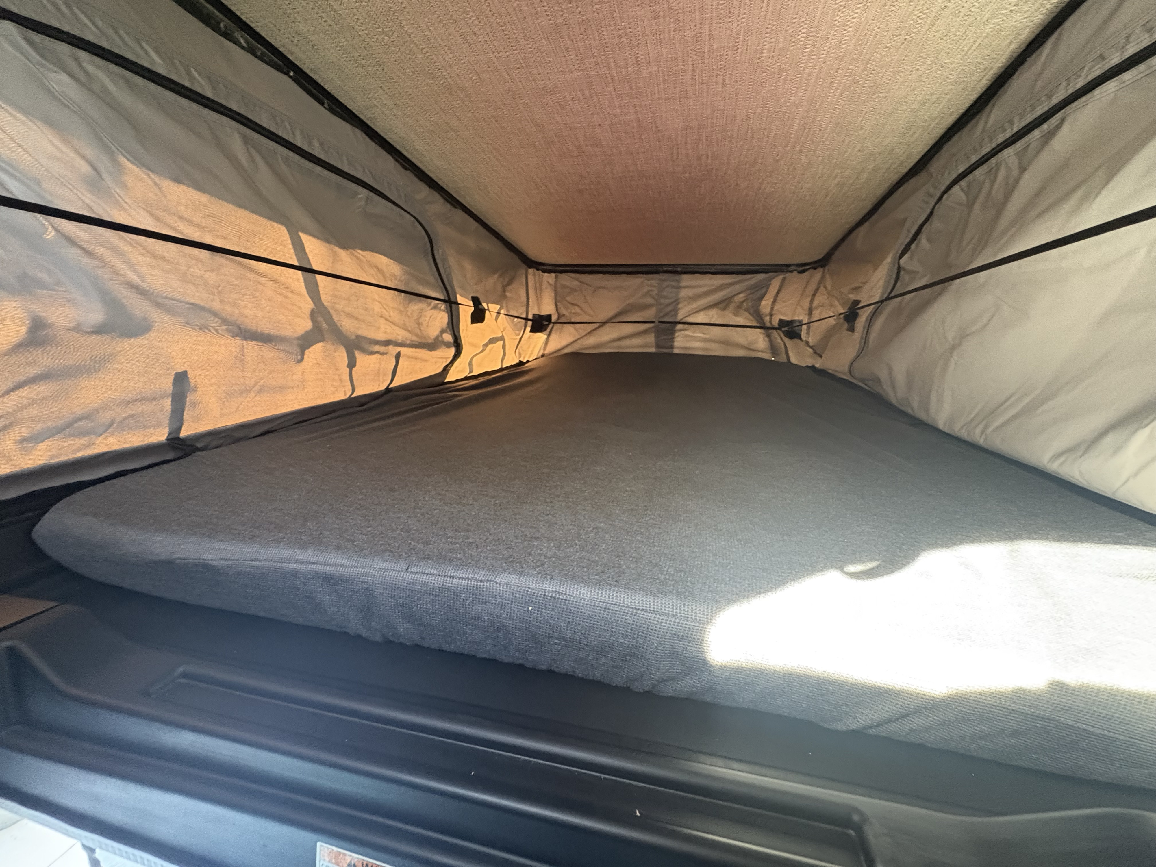 Inside an RV rental, a pop-up tent's cozy sleeping area features a comfortable mattress and mesh windows for camping.. 3c6mrvjg9se527066 Winnebago 2026