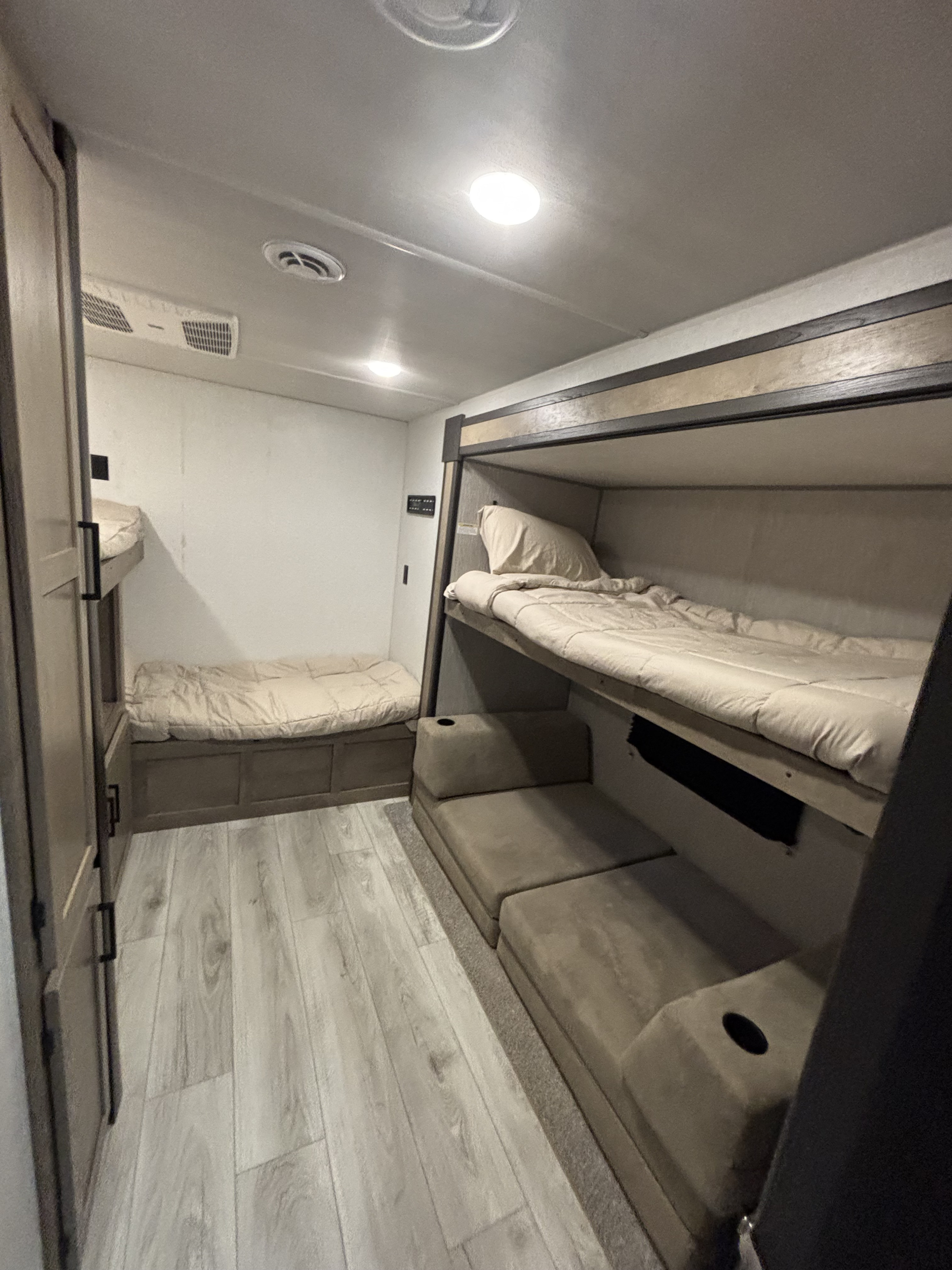 Well-lit RV rental bunk room with comfortable sleeping for multiple guests, modern decor, and ceiling amenities.. Keystone RV Springdale Premium 2025