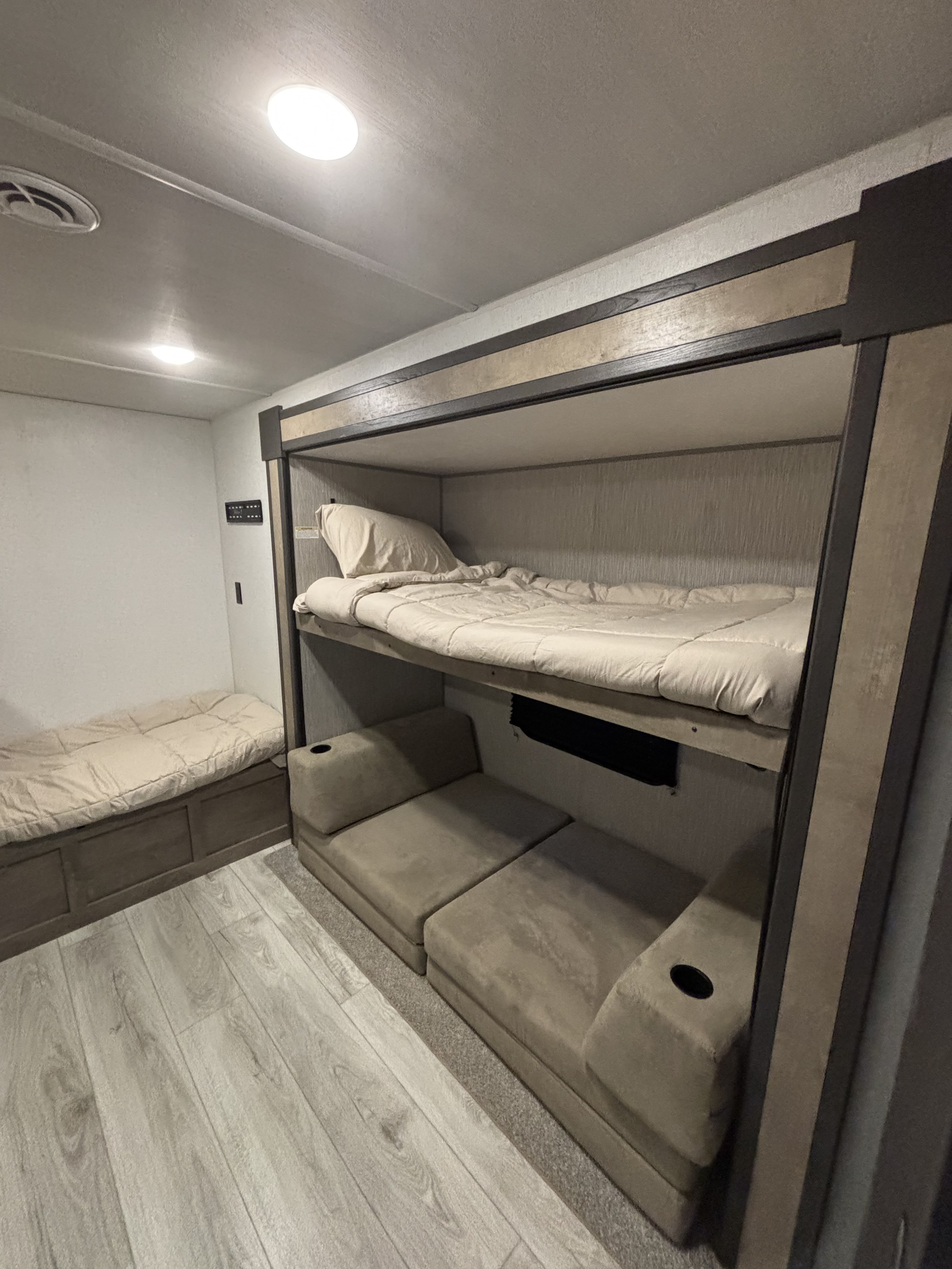 Cozy RV rental interior featuring bunk beds, a lower convertible couch/bed, and an additional sleeping bench.. Keystone RV Springdale Premium 2025