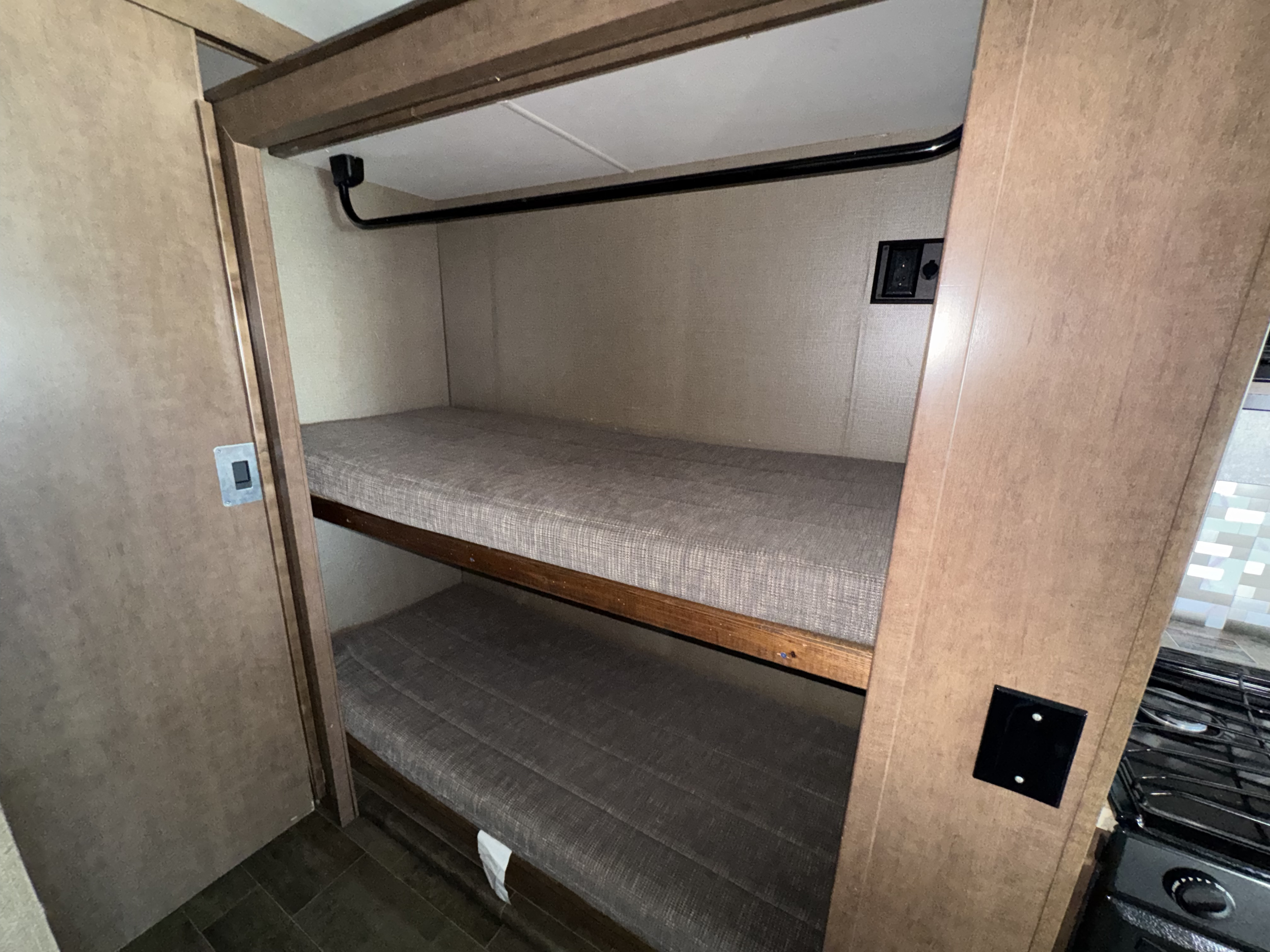 Compact rv rental bunk beds feature grey mattresses and a power outlet, ideal for kids' sleeping space.. Winnebago Intent 2018