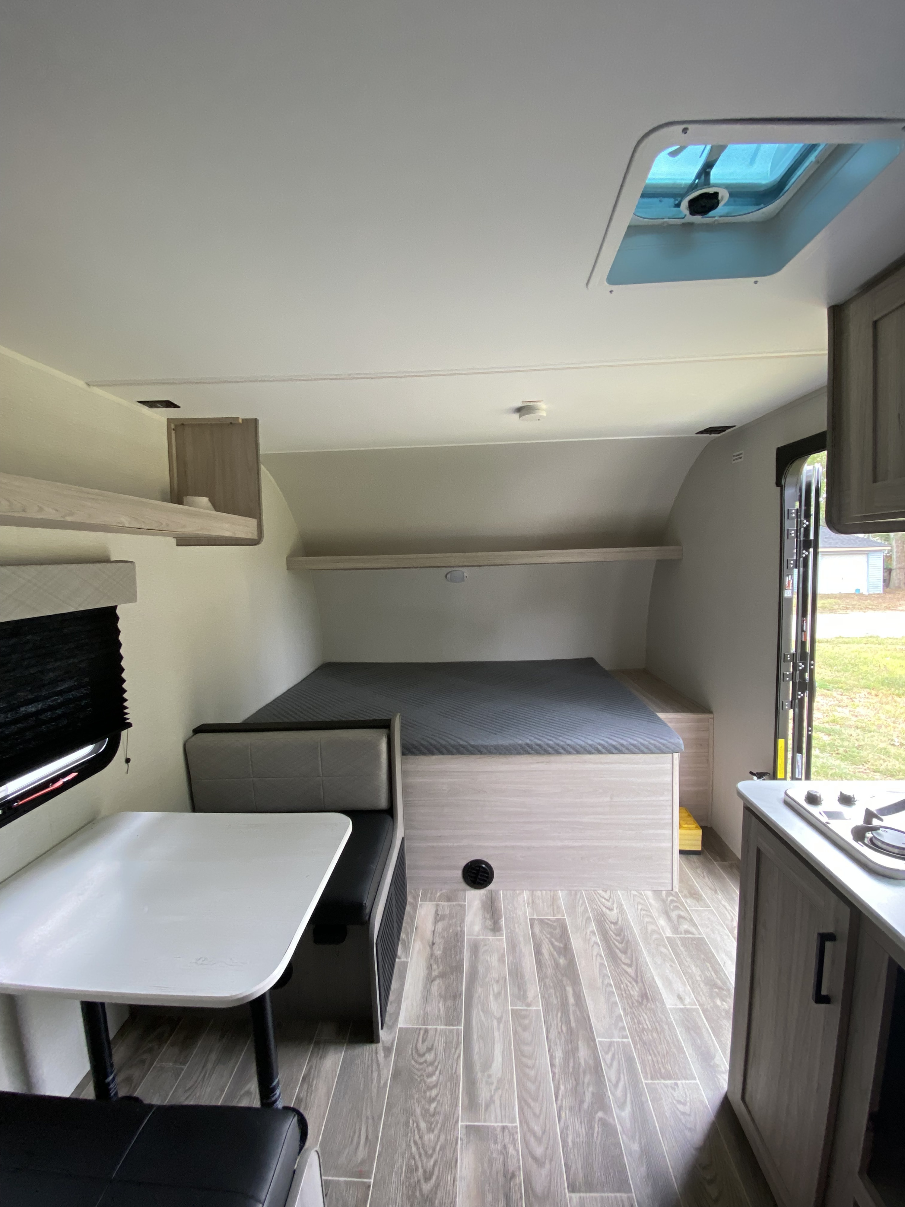 Bright RV rental interior featuring a compact dining area, bed, and kitchenette for comfortable travel.. Heartland RVs Mallard 2025