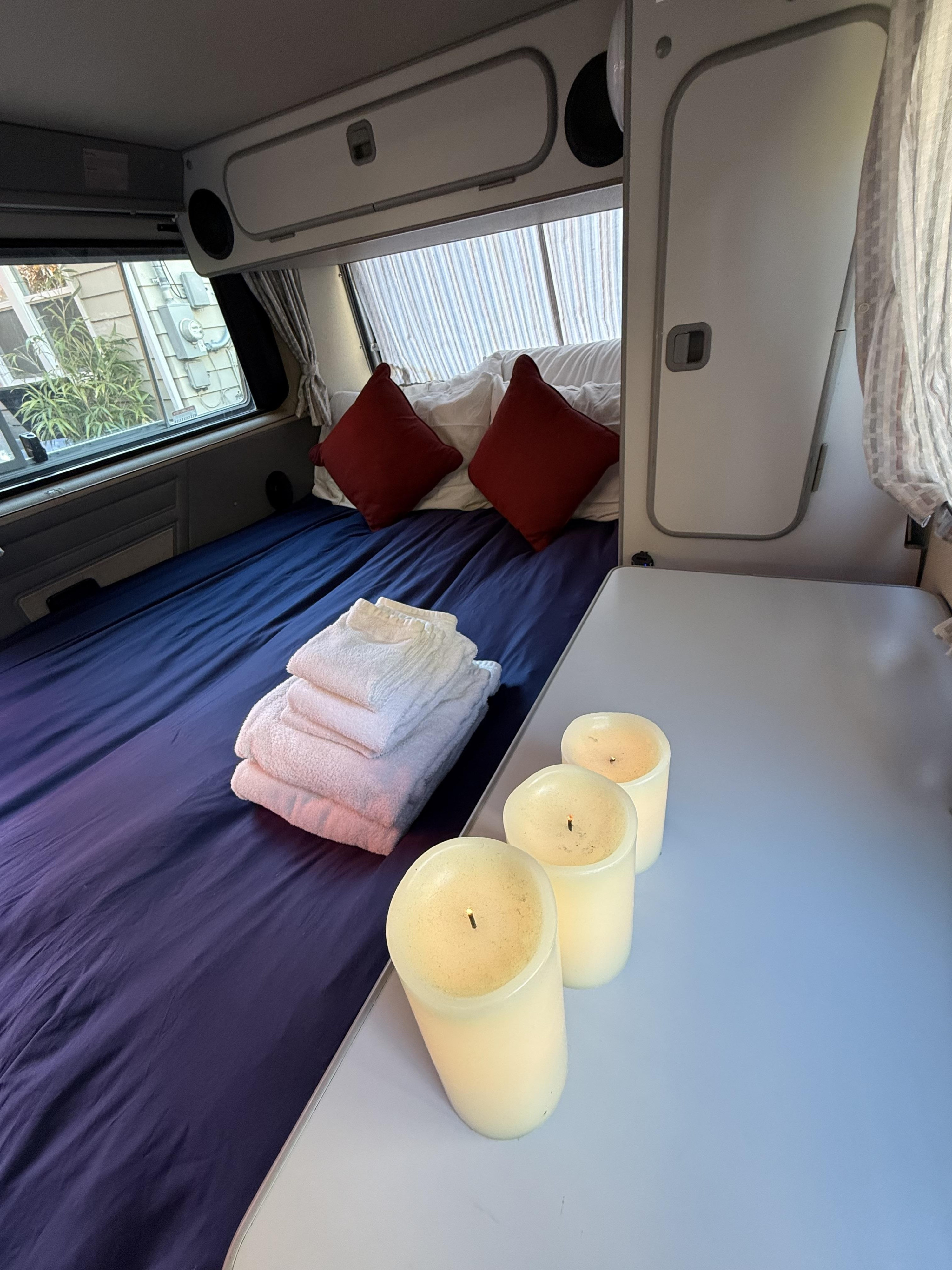 Relax in comfort! RV rental interior with a neatly made bed, fresh towels, and decorative candles on the table.. Volkswagen T3 Westfalia 1991
