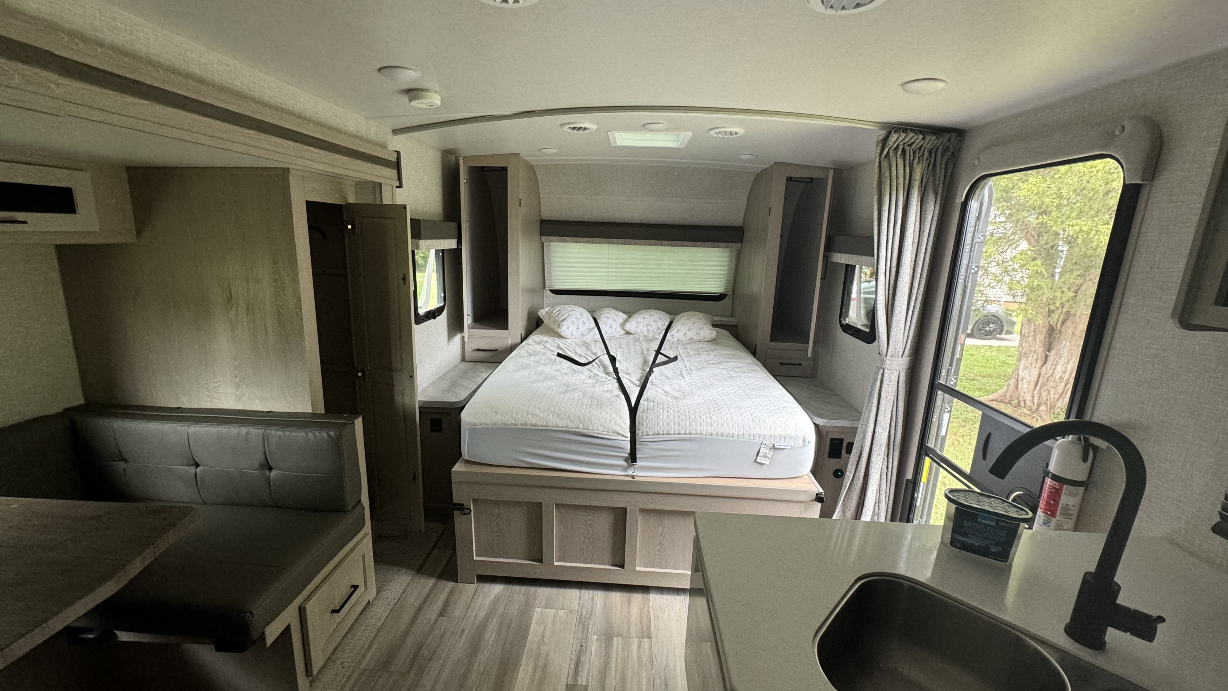 RV rental interior: comfy bed, ample storage, a dinette, and kitchen sink are visible, offering home-like amenities on the road.. Forest River Flagstaff Micro Lite 2023